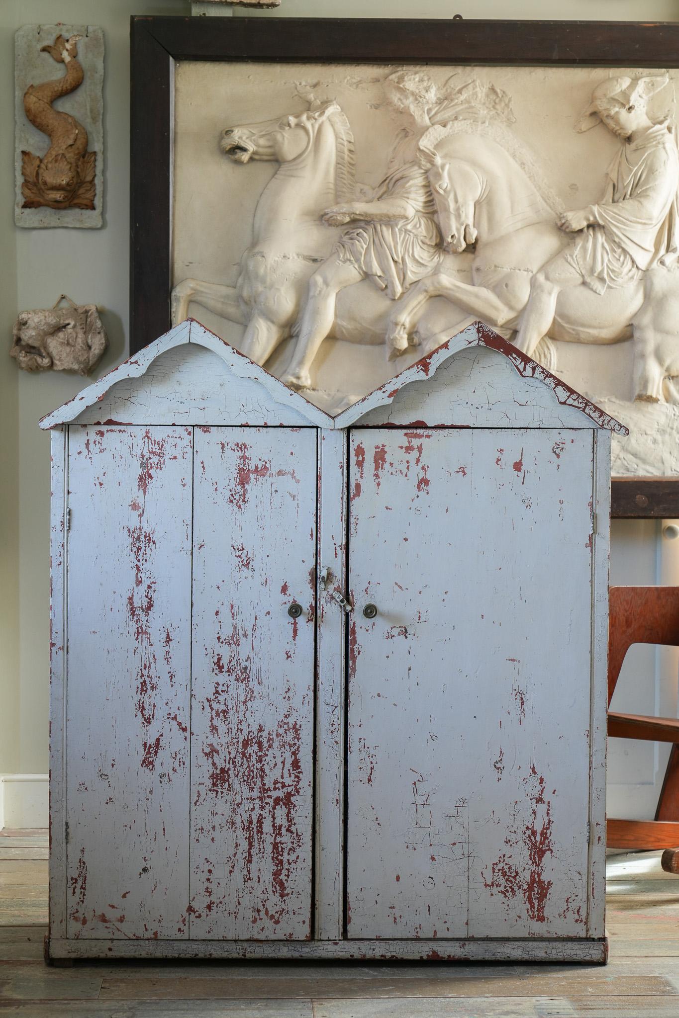 A two door painted pine cupboard with a twin faux cottage roof. 

English, Devon, circa 1810. 

Provenance: Hatch Court, Hatch Beauchamp, Somerset.