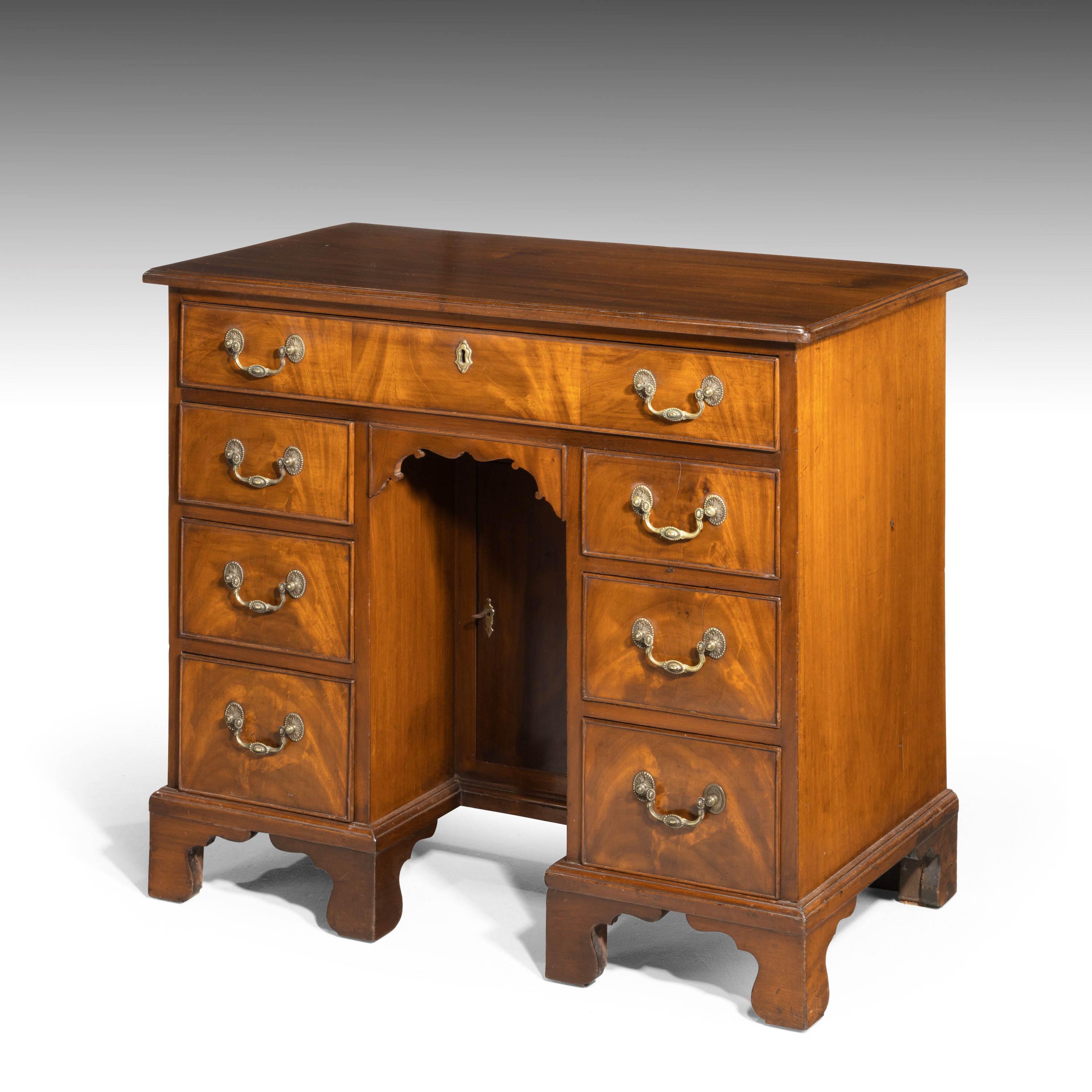 A George III period mahogany kneeholes desk of small proportions. With good original bracket feet and finely cast swan neck handles. With a central cupboard.
 