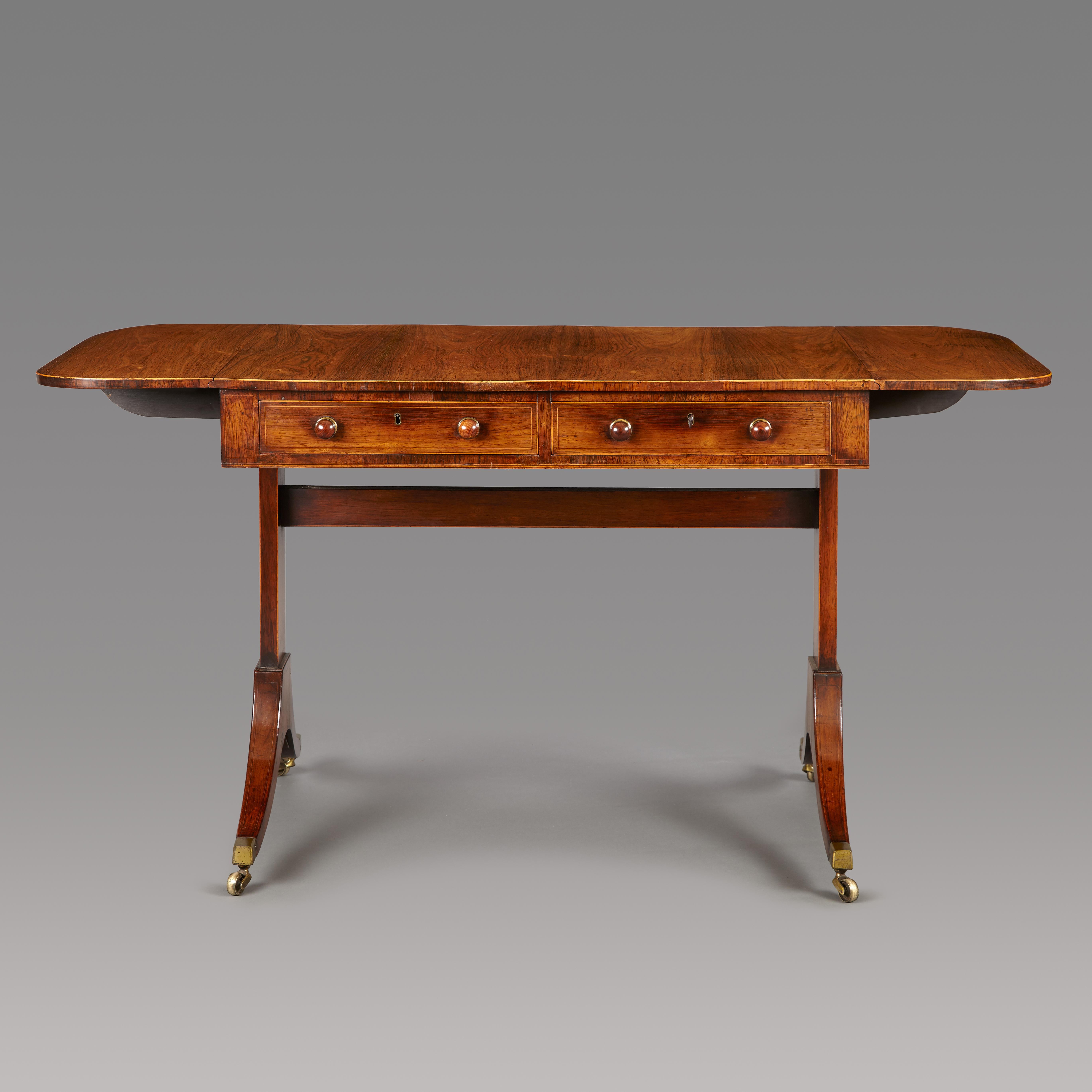 An elegant George III period century rosewood sofa table of good proportions. The well figured veneered top having a Boxwood line inlay to the edge, the two drawers and two faux drawers also inlaid to match. The drawers fitted with the original