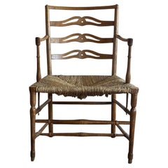 A George III provincial low pierced ladder-back armchair