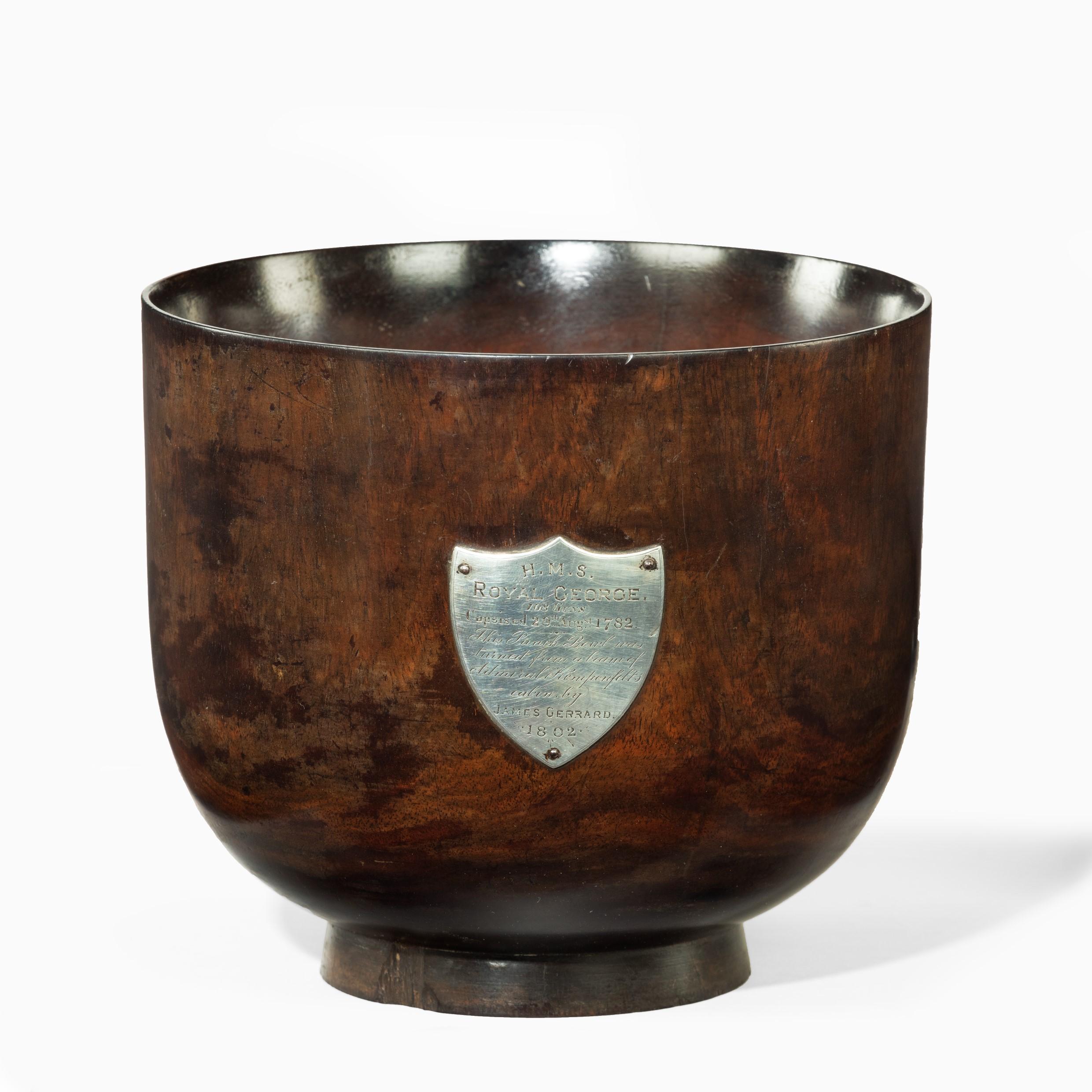 This turned commemorative oak bowl is of deep cylindrical form applied with a silver shield-shaped plaque inscribed ‘H.M.S. Royal George. (108 Guns) Capsised 29th Augst. 1782. This Punch Bowl was turned from a beam of Admiral Kempenfelts cabin, by