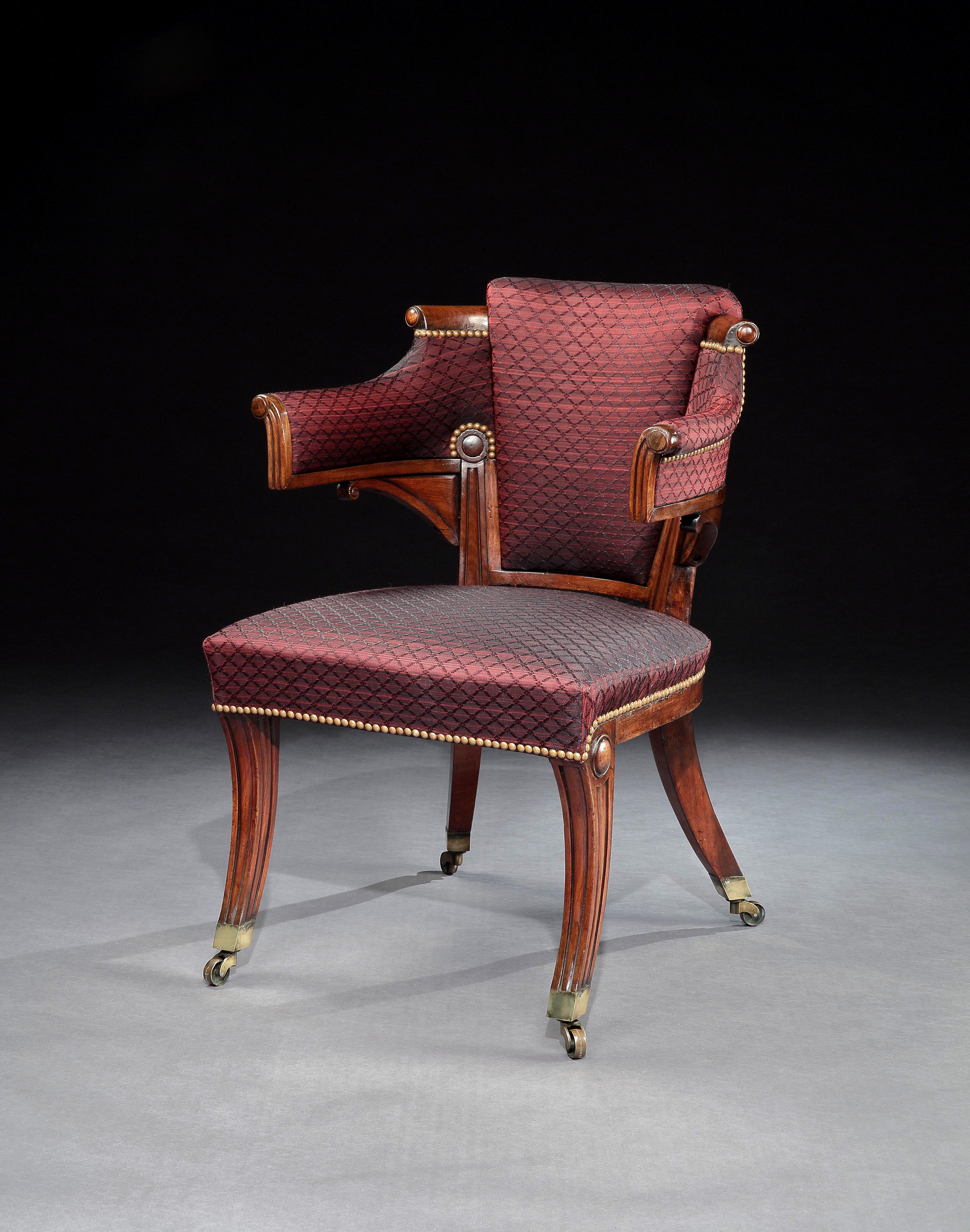 A rare and unusual Regency mahogany armchair of particularly pleasing form with outscrolled arms and standing on molded sabre legs with brass box castors, covered in burgundy horsehair and finished with brass studs.