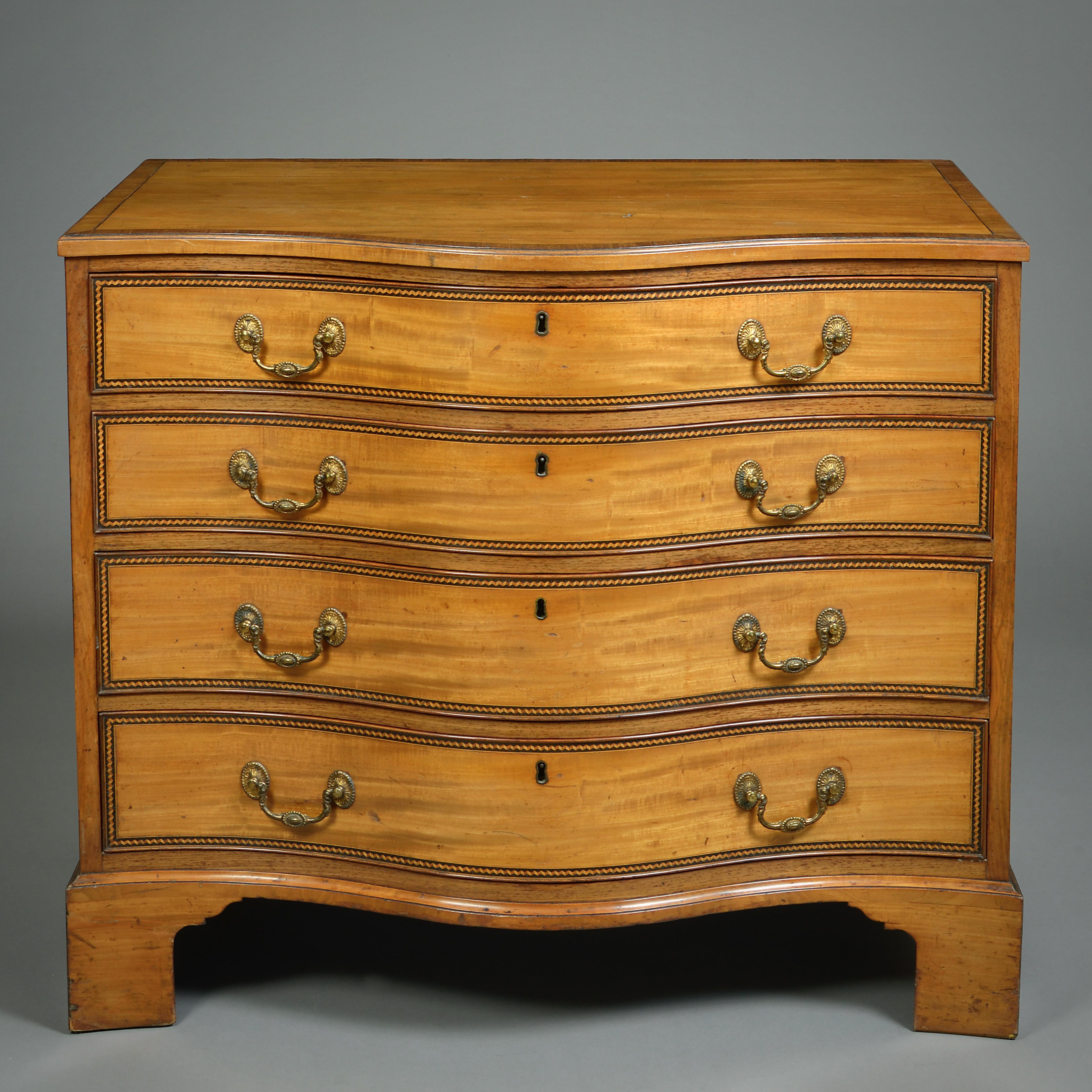 A FINE GEORGE III SATINWOOD SERPENTINE COMMODE, CIRCA 1780.

Cross-banded in tulipwood, the drawers edged with a trompe l'oeil zig-zag banding.
