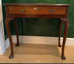A George III side table in quarter sawn oak with a single drawer and pad feet. 