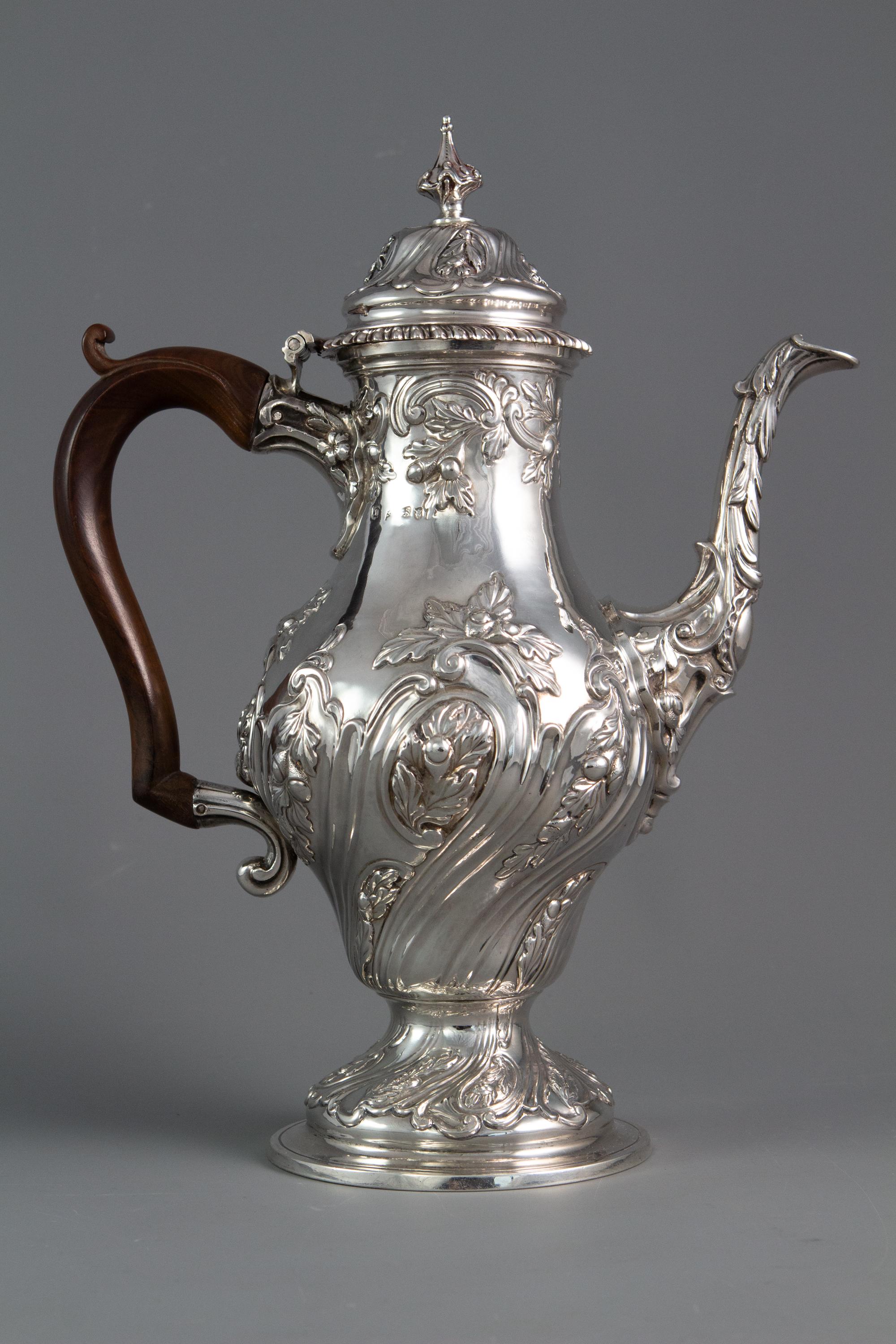 A George III silver coffee pot, London 1769 by William Abdy. The body of double pear-shaped form with embossed spiral-fluted foliate decoration. A floral decorated cast spout and handle mountings. The hinged lid with matching decoration and a
