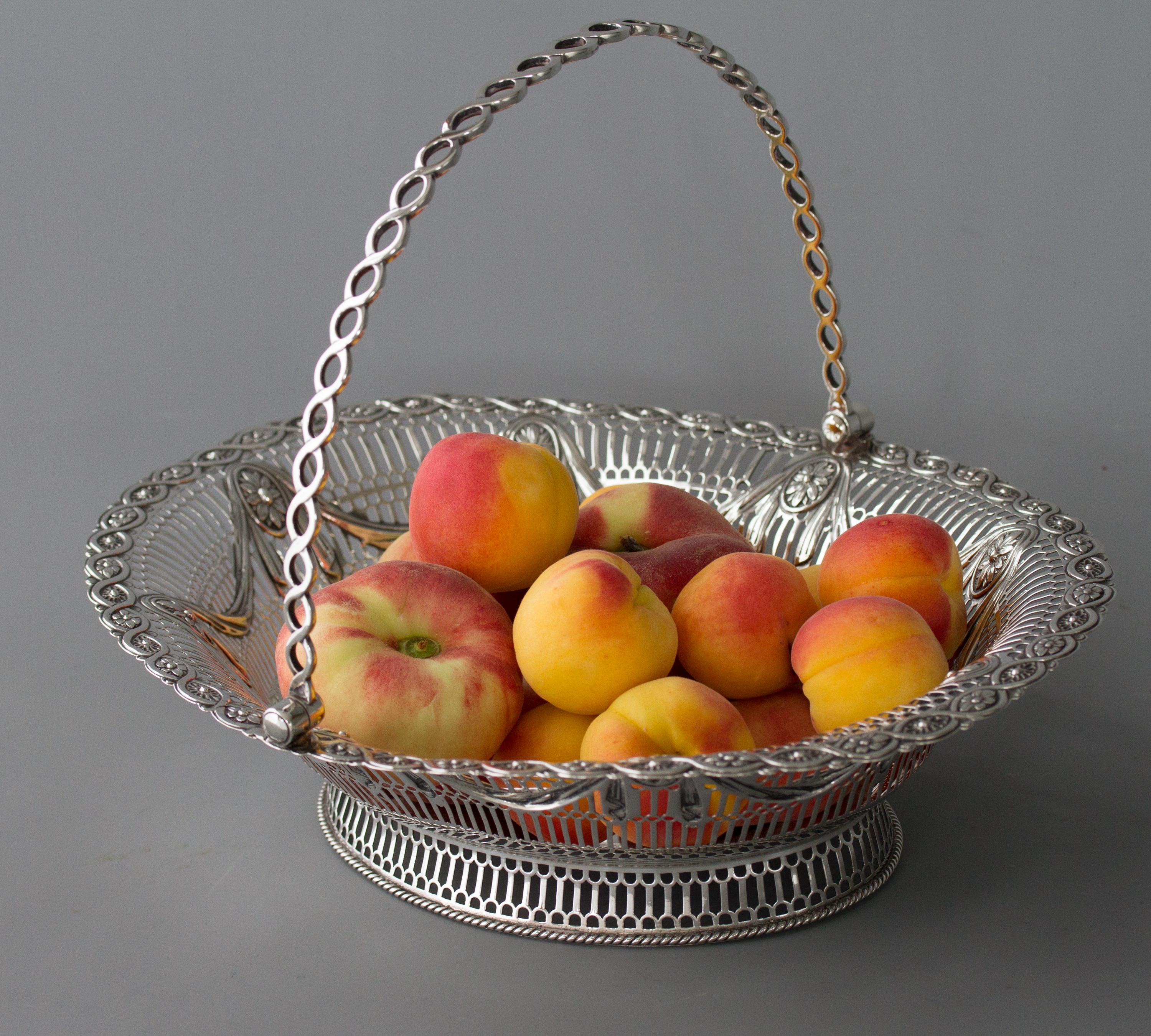 A superb oval George III silver basket by Aldridge & Green, London 1774. Of oval form, the pierced sides embossed and chased with a floral, swag drapery design, and floral boarder. Rope twist pierced handle all standing on a pierced