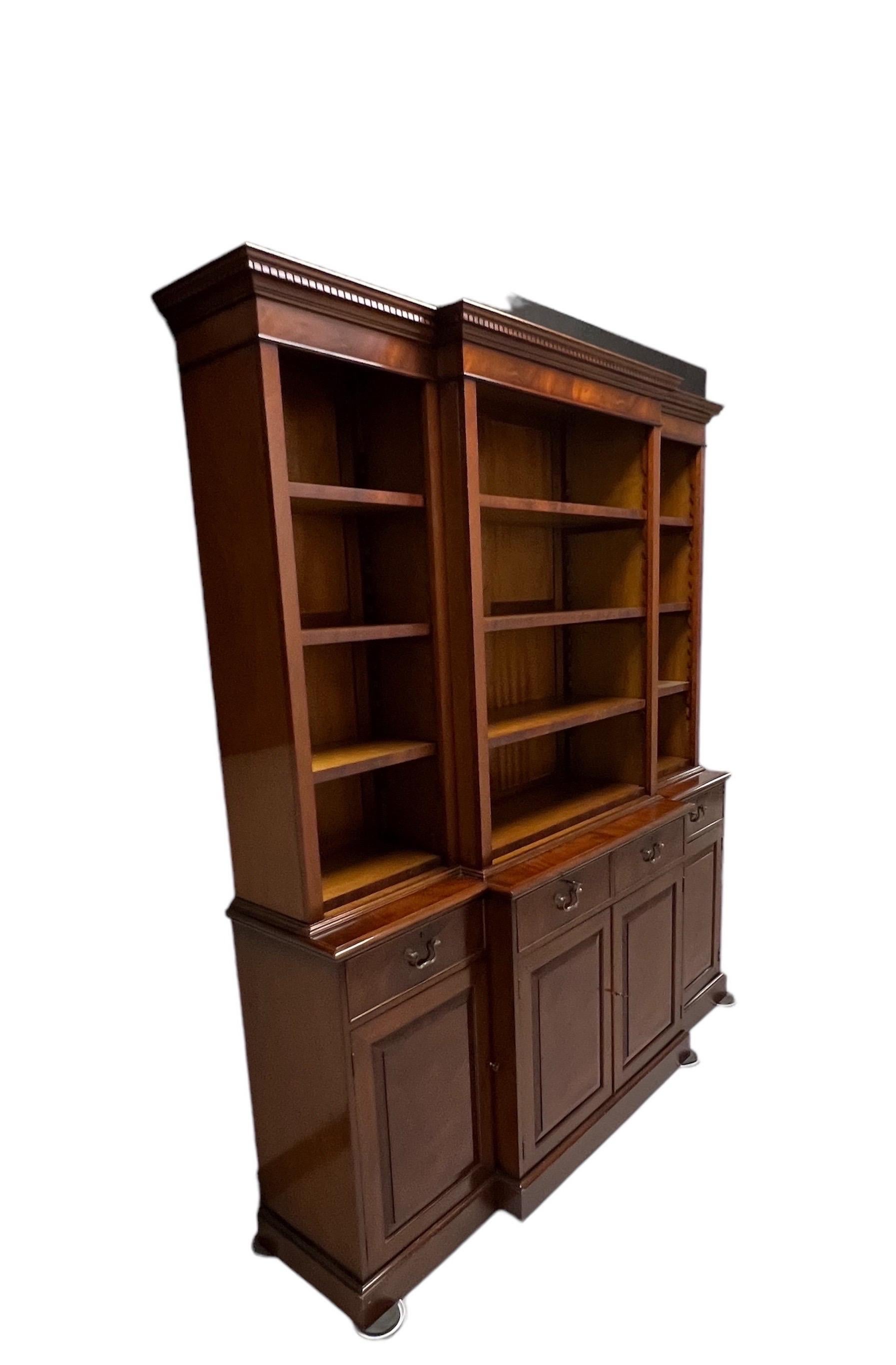 A George III Style Mahogany Breakfront Bookcase
With open bookshelf configuration on the top. With 12 adjustable bookshelves on the top, half and four stationary shelves inside the lowercase section also with four drawers. 3 keys 