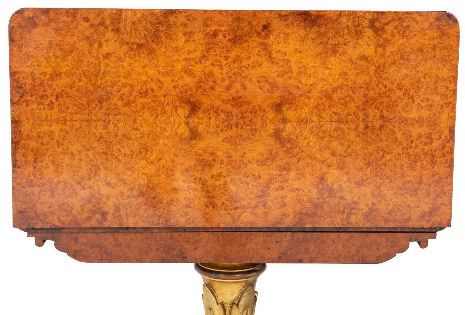 Voici une superbe table à cartes en amboyna George IV, ornée d'une décoration exquise en bois doré, qui illustre le summum de l'artisanat d'art de l'époque anglaise vers 1830.

Cette table remarquable est dotée d'un plateau pivotant qui se replie