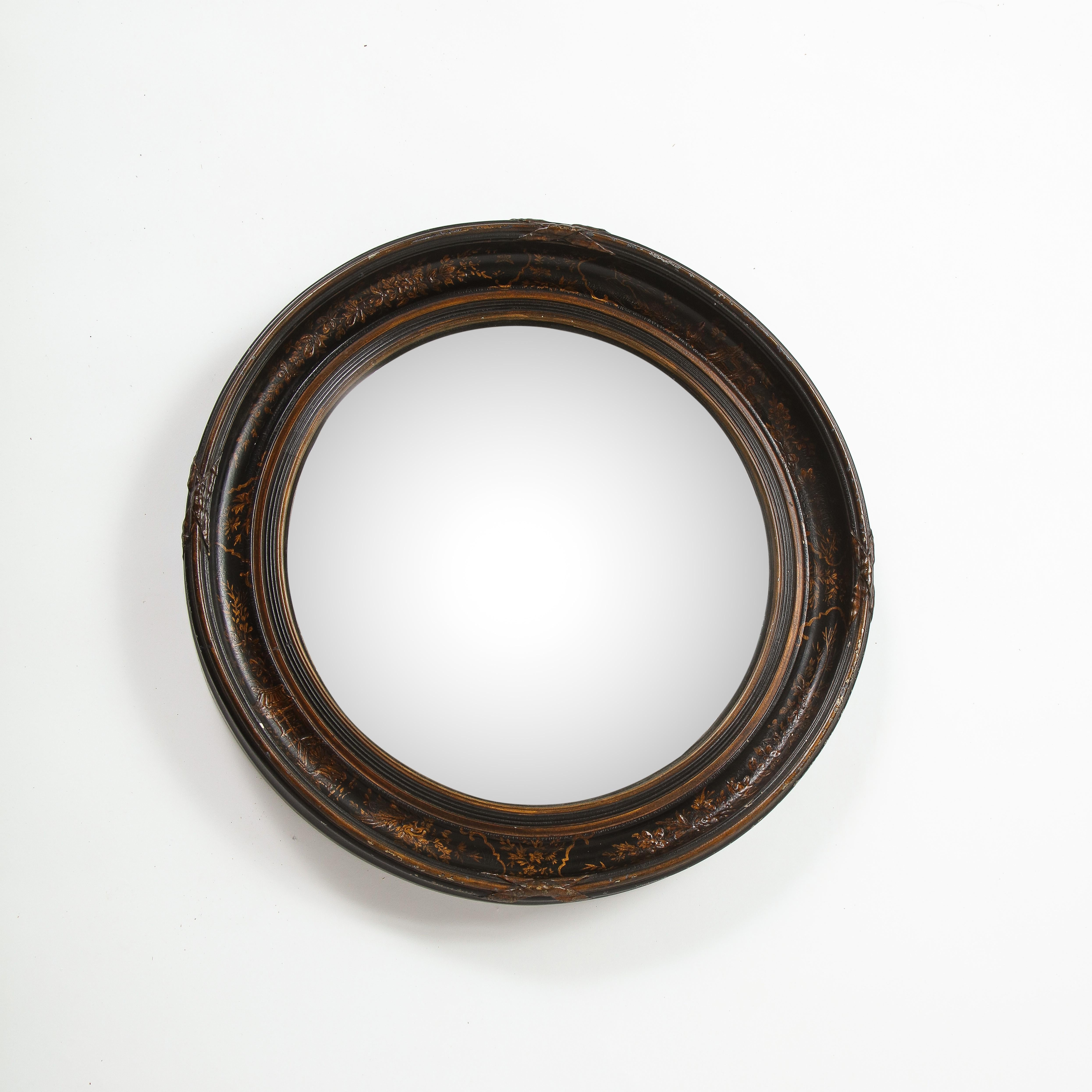 The round mirror plate within a reeded ebonized slip and channeled surround with chinoiserie japanned decoration on a black ground; the outer edge enriched with fasces ornament.
