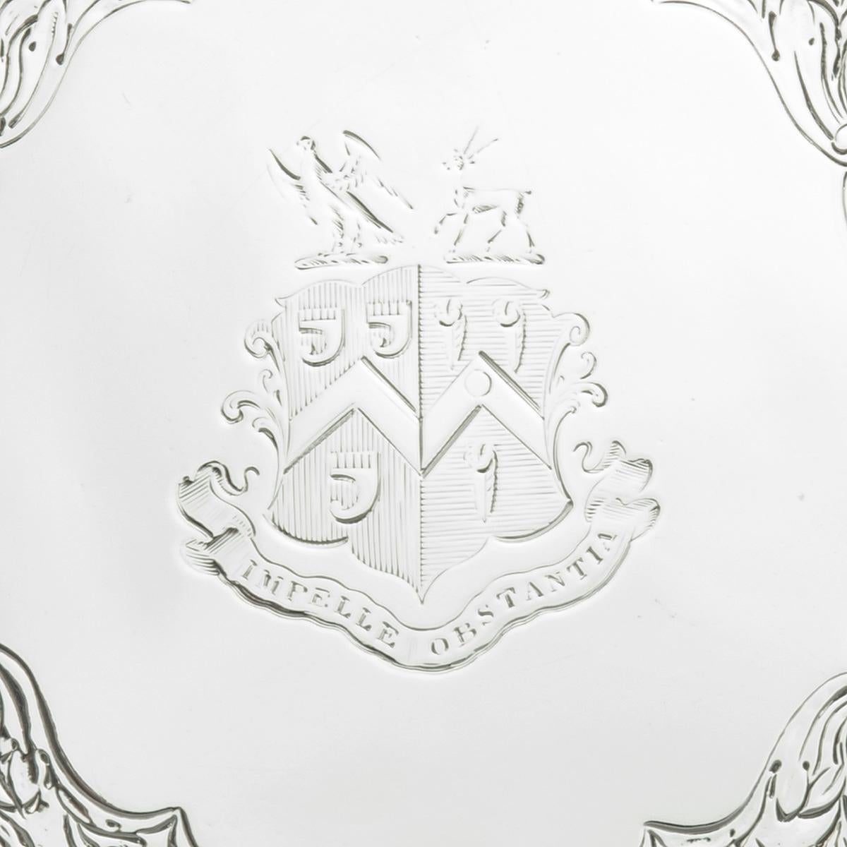 A George IV crested silver tray commemorating the marriage of Lieutenant Colonel Thomas Arthur, 3rd Dragoon Guards, of circular form, raised upon three claw and ball feet with a shell and scroll raised border, the central incised crest and motto
