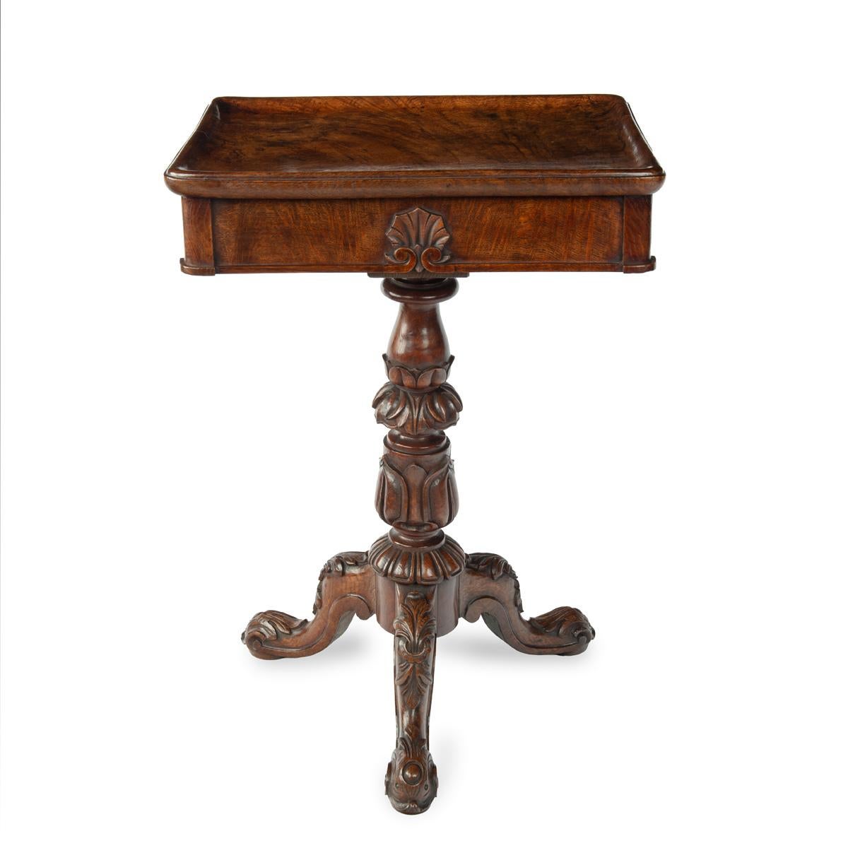 A George IV highly figured oak tripod side table attributed to Gillows, the rectangular top made from a single, solid piece of oak, with a frieze drawer on one end, raised on a turned, acanthus carved baluster support with three scroll legs.