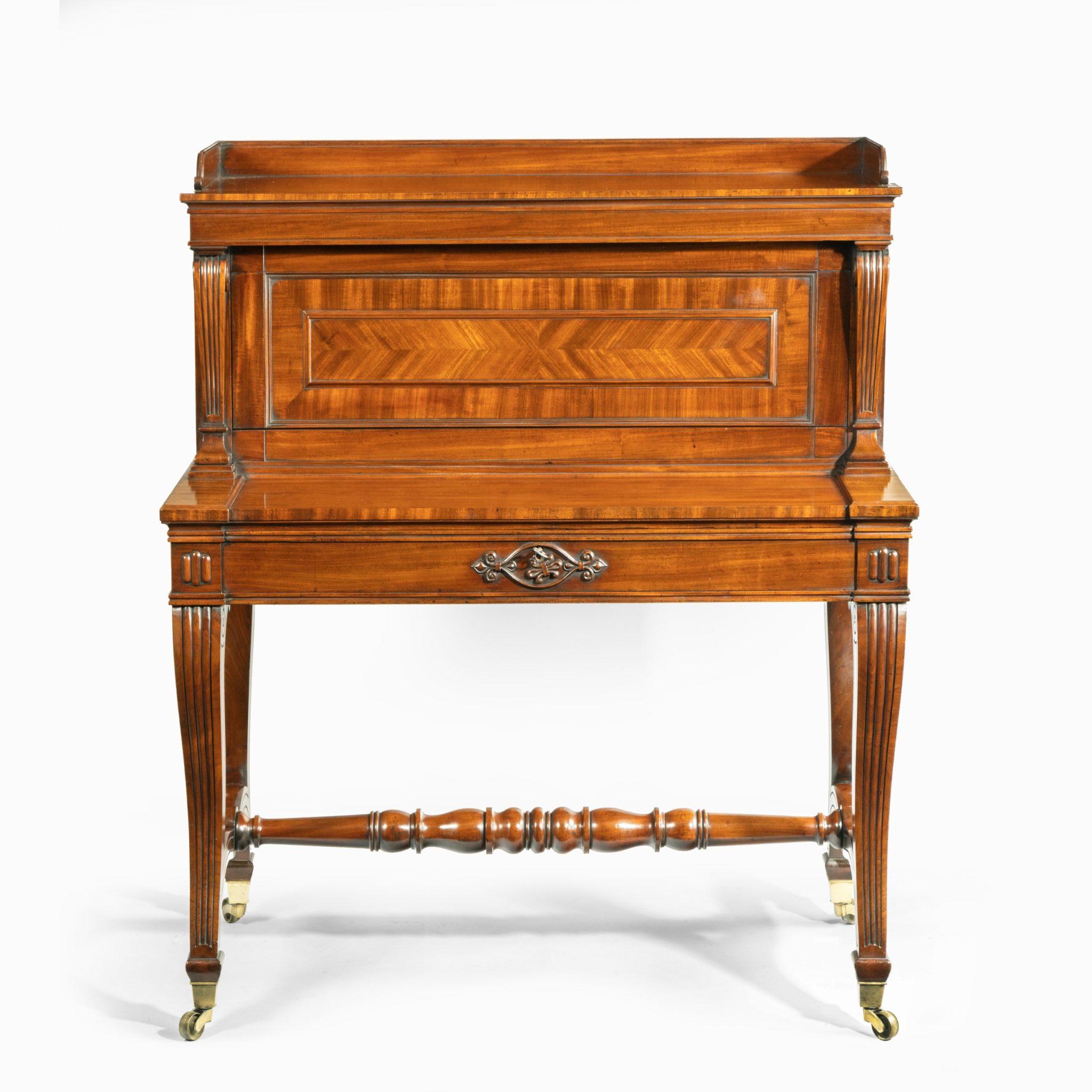 A George IV mahogany mechanical escritoire attributed to Gillows, of rectangular form with a vertical superstructure on reeded cabriole legs with a turned stretcher and the original brass castors, pulling out the frieze drawer triggers a mechanism