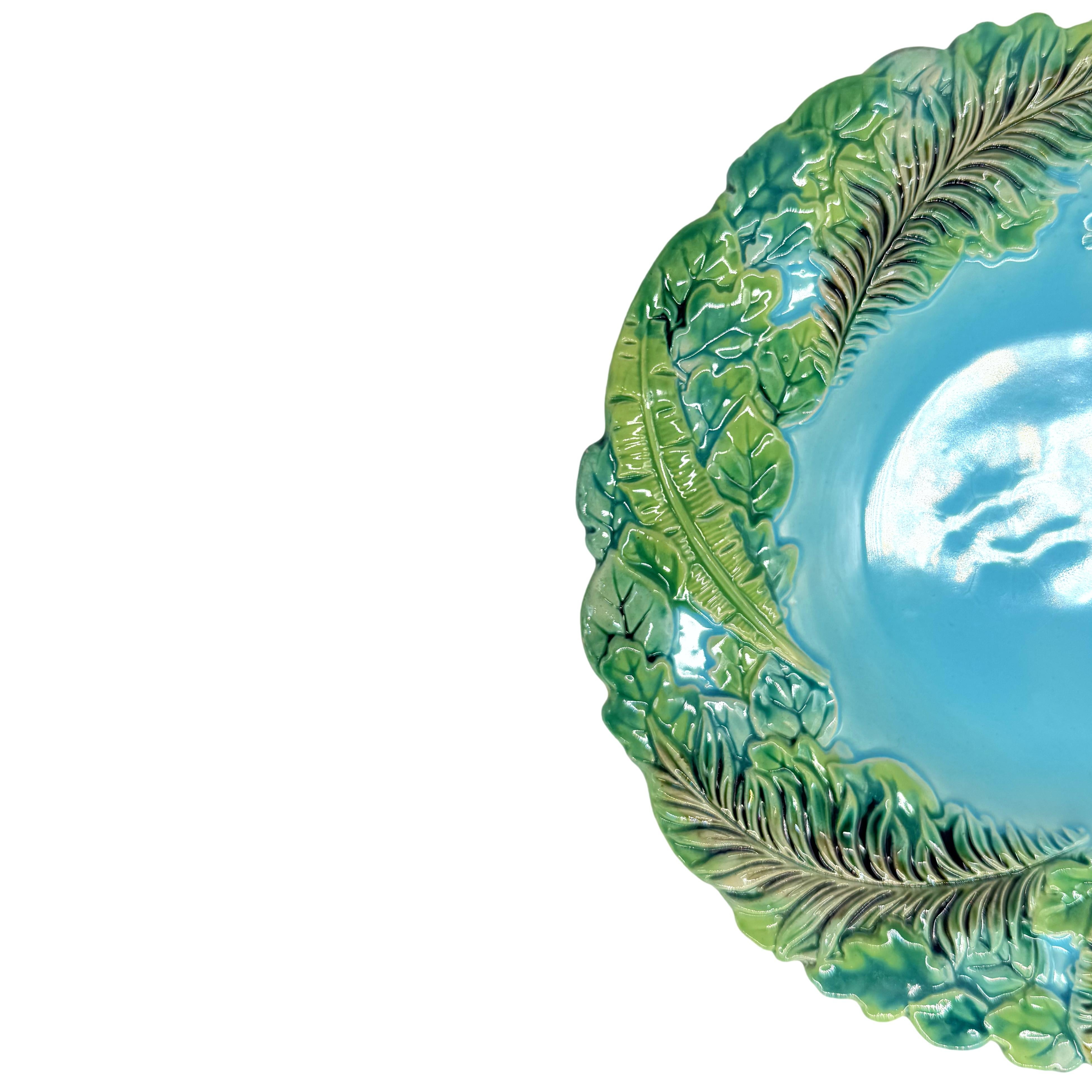 A George Jones Majolica Plate with green-glazed relief molded palm and banana leaves on a turquoise ground.  This design is included in the Karmason Stake Library of the Majolica International Society, number KL000046 with the designation rare.  
