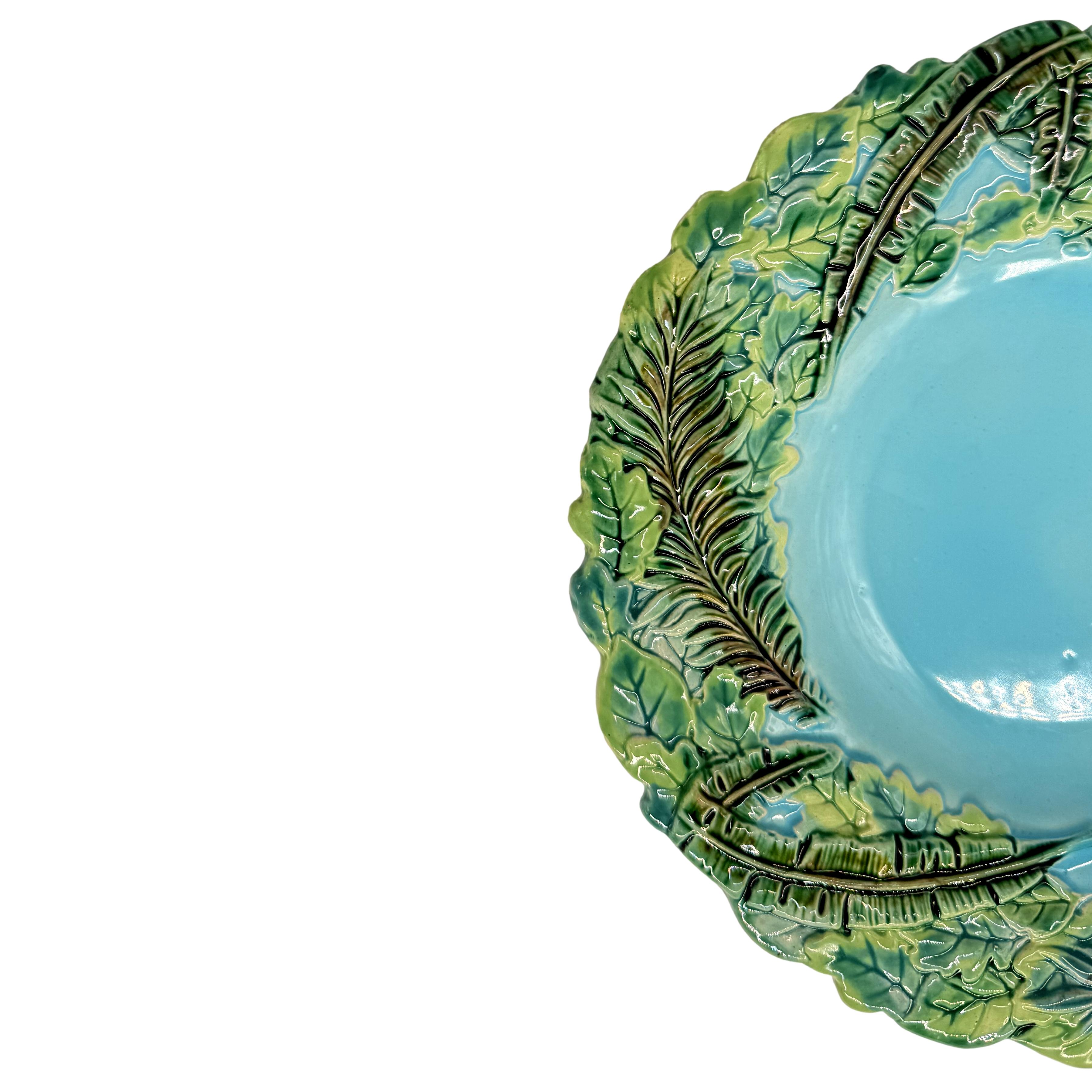 A George Jones Majolica Plate with green-glazed relief molded palm and banana leaves on a turquoise ground.  This design is included in the Karmason Stake Library of the Majolica International Society, number KL000046 with the designation rare.  
