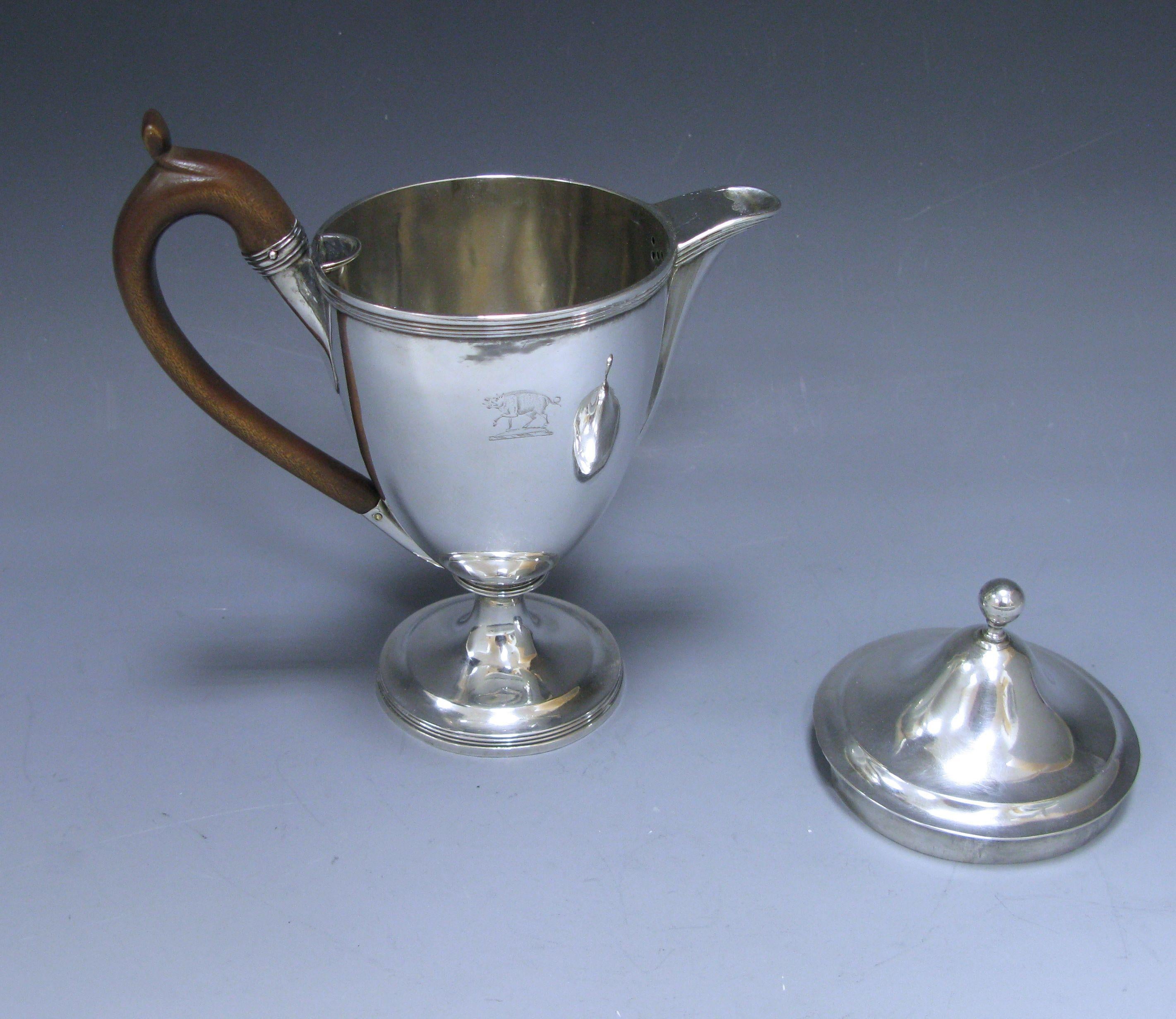 A very elegant George III antique silver argyle, with a vase shaped body which has reed border on the base and top of main body. The pull of lid has a ball finial. The argyle has a fruitwood handle. The body is engraved with the crest of Robert