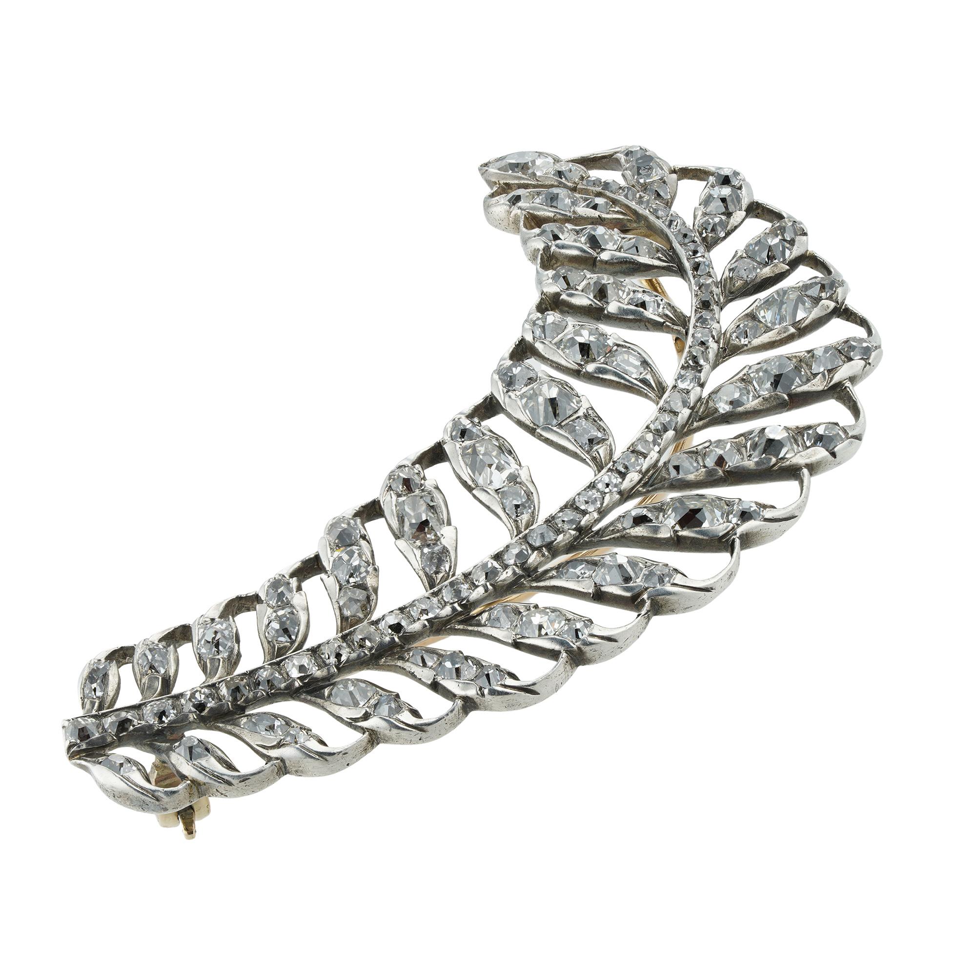 A Georgian diamond-set brooch in the form of a curved feather, set with hundred and six old-cut diamonds, estimated to weigh a total of 3 carats, all mounted in silver to a close back mount, with a rose gold brooch fitting, and later yellow gold