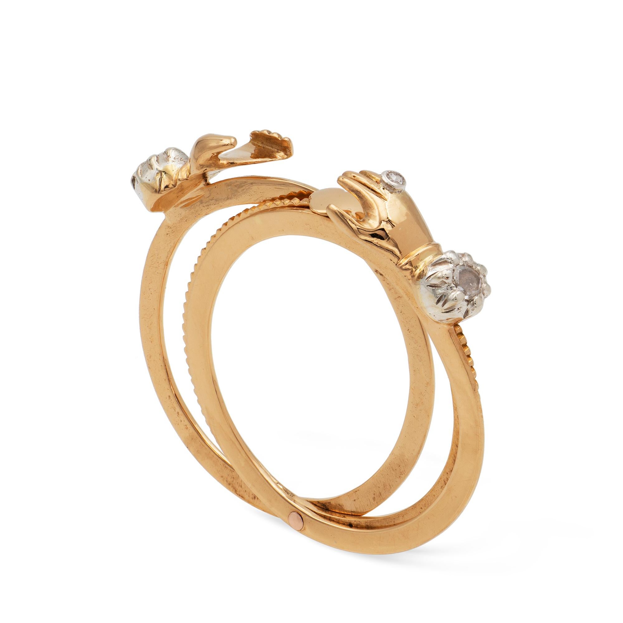 A Georgian fedé and gimmel ring, consisting of two outer flat and one middle ridged yellow gold hoops linked together, with the same shank split lengthwise so the hoops fit together unnoticeably as one, embellished with two interlocking hands,