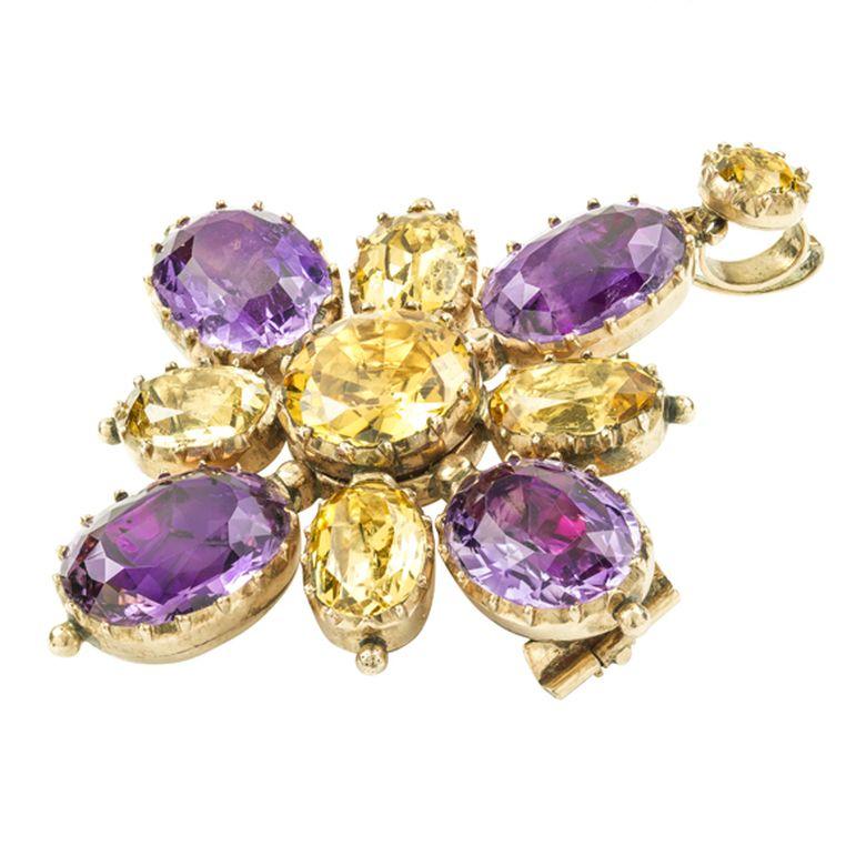 A Georgian golden topaz and amethyst cross brooch-pendant, the pendant in the form of a cross with a round faceted topaz centre, oval faceted amethyst arms and oval faceted topaz in between suspended from a smaller round faceted topaz pendant loop