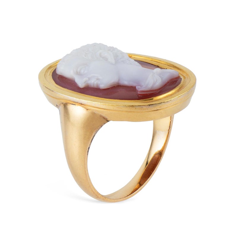 A Georgian hardstone cameo ring, the oval-shaped cameo depicting the profile of a patrician, rub-over set within a yellow gold mount with ridged detail to the rim, to a tapered yellow gold shank, circa 1820, the head measuring 25 x 19mm, finger size