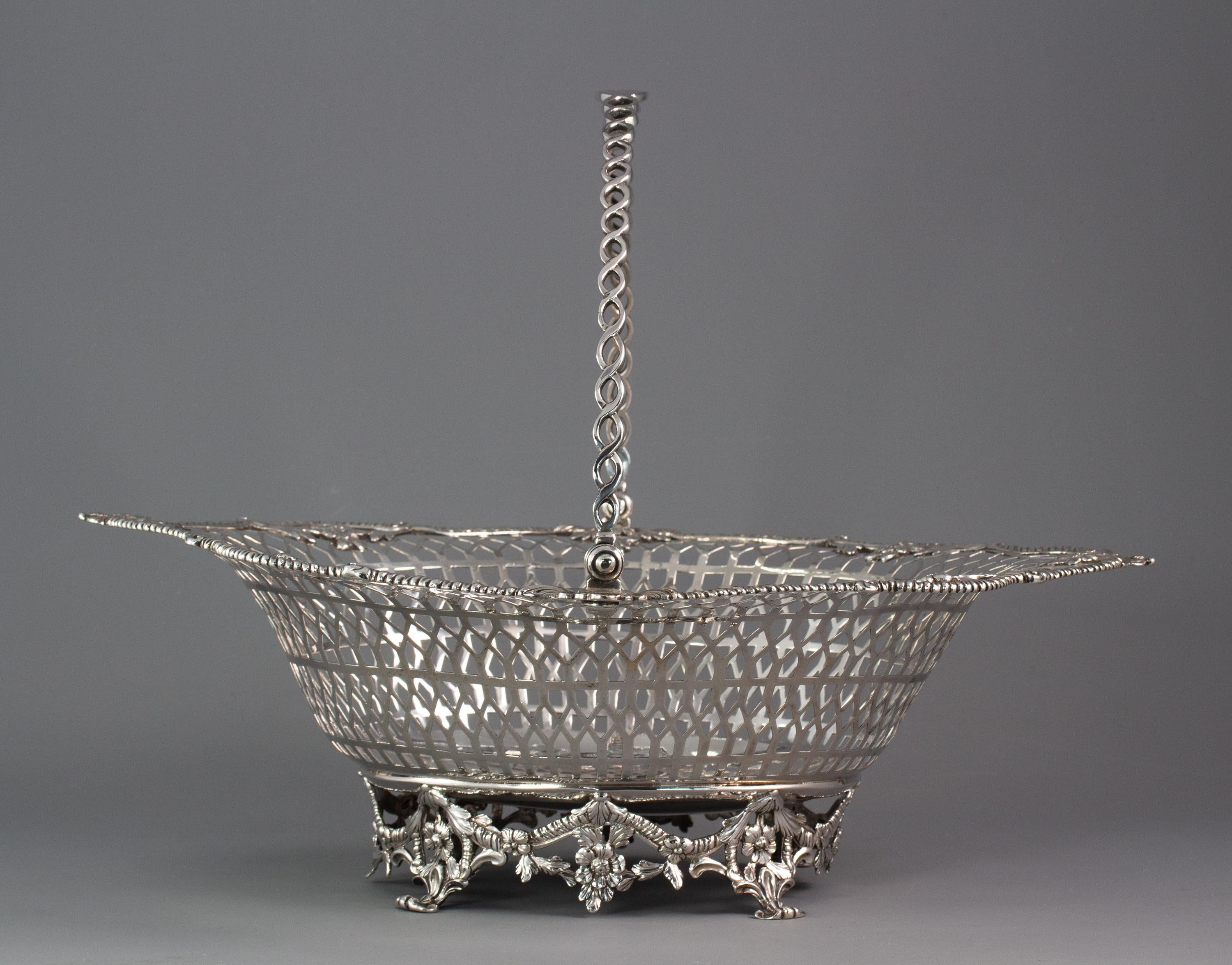 A superb Georgian Irish silver basket Dublin, 1760

 Spectacular pierced Irish silver bread or cake basket of shaped oval form. The swing handle of pierced graduated circlets. The shaped rim with gadrooned edges and cast flowers and foliage. The