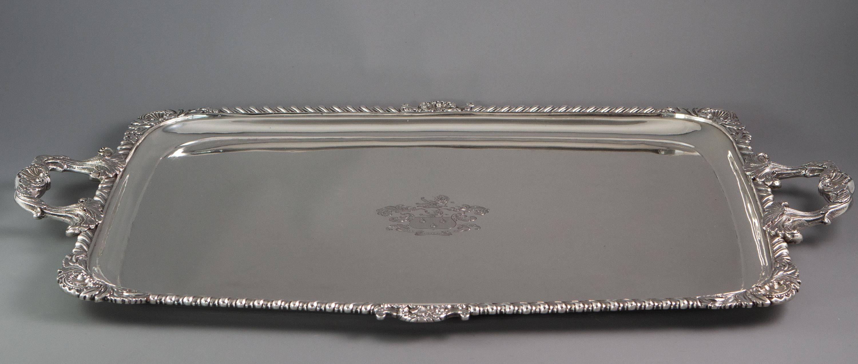 A very fine Irish Georgian twin handled silver tea or drinks tray with shell and scroll corners and gadrooned edges. The cast and applied handles with sheaves of leaves and shell and anthemion decoration. The central plate engraved with an armorial