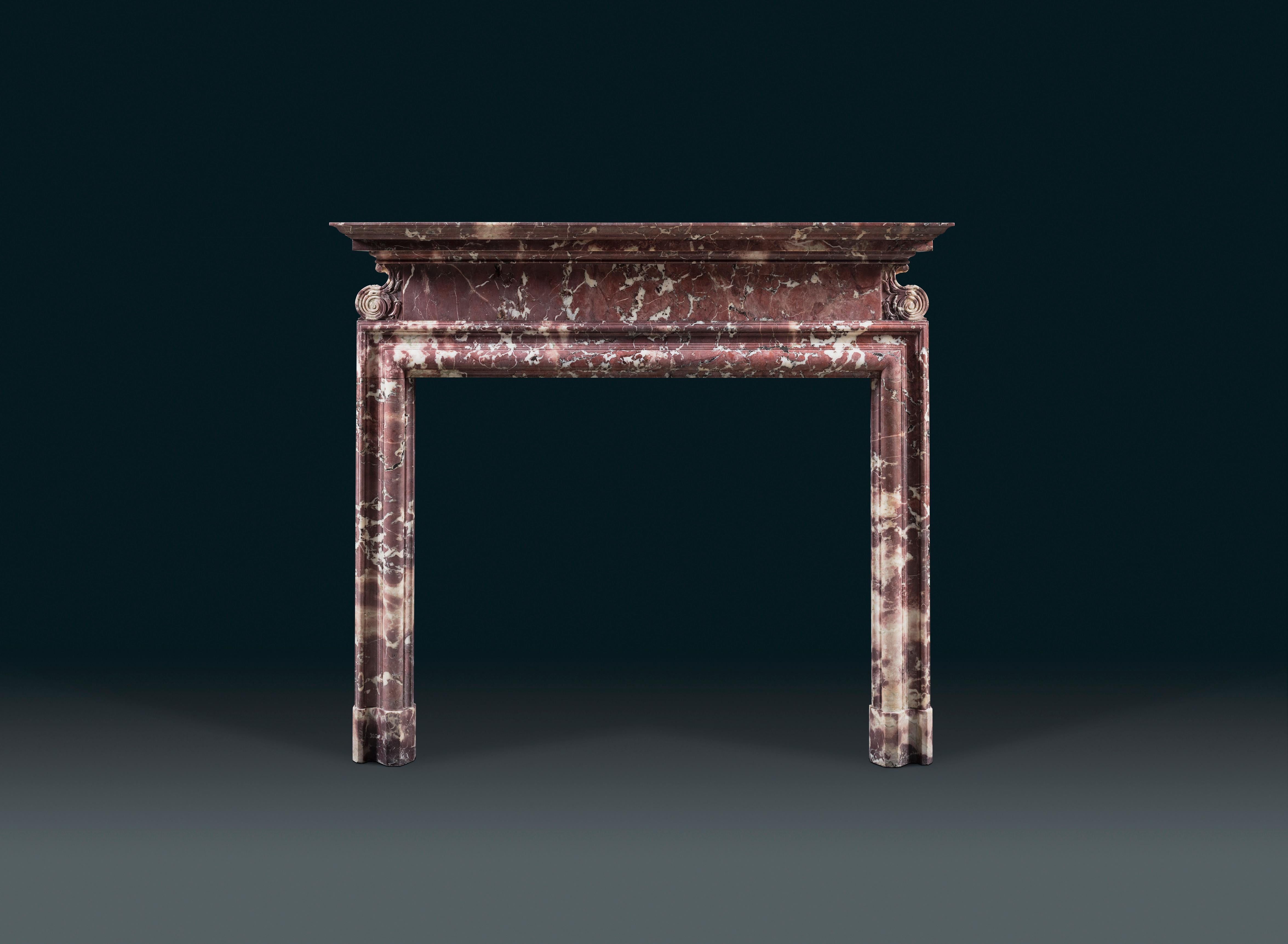 A fine Georgian Revival bolection chimneypiece carved in Breccia Medicea marble with a moulded shelf above a plain frieze flanked by Baroque S scrolls, carved robustly with flourishes of acanthus. Likely by Hoppin & Koen of New York City in New
