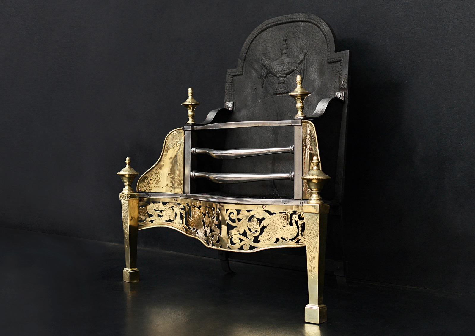 A mid 19th century Georgian style brass and steel firegrate. The deep engraved fret with storks, scrolls and urn to centre. Engraved side wings, finials and feet, shaped front bars and cast iron back with urn.

Width At Front:	745 mm      	29