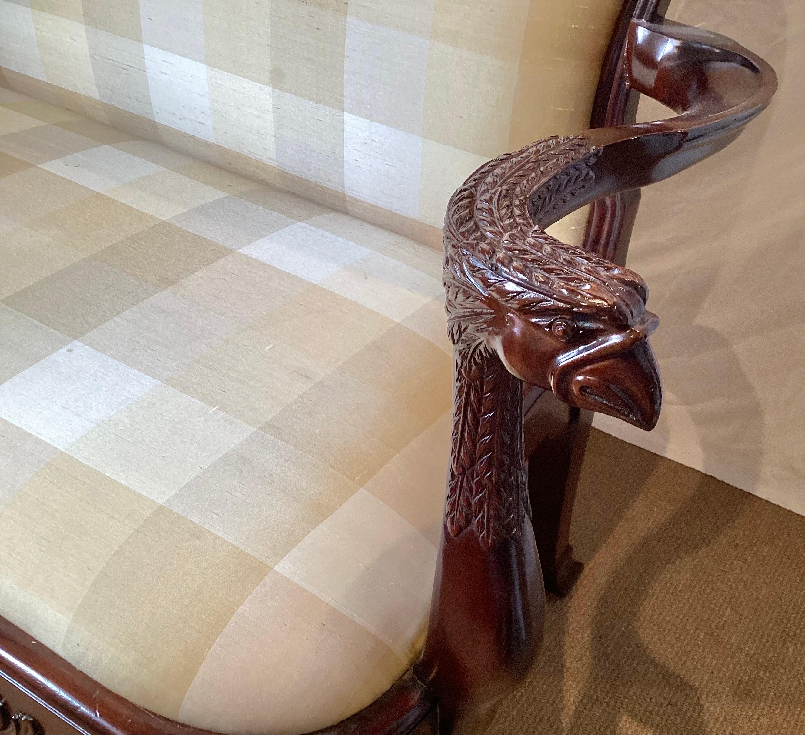 A shapely hand carved mahogany settee by Maitland Smith.  The shapely frame with rounded corners, hand carved arms in the form of a bird with detailed carved legs and apron.  The silk plaid fabric is original with some staining that can easily be
