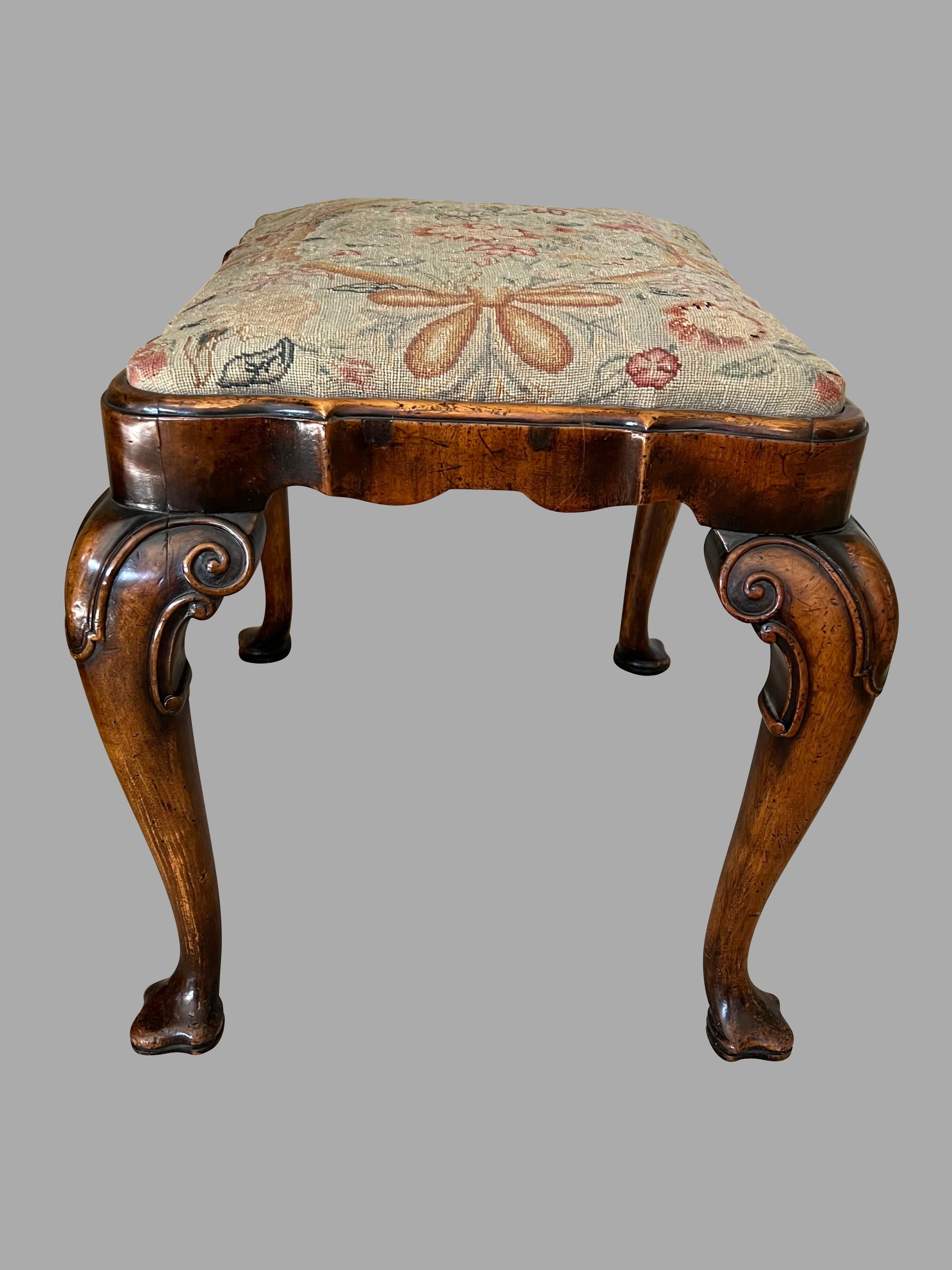 A fine quality George II style walnut bench with cabriole legs ending in trifed feet. The piece was made and signed by W. Charles Tozer a maker and retailer of high quality furniture, specializing in early Georgian and Queen Anne walnut revival