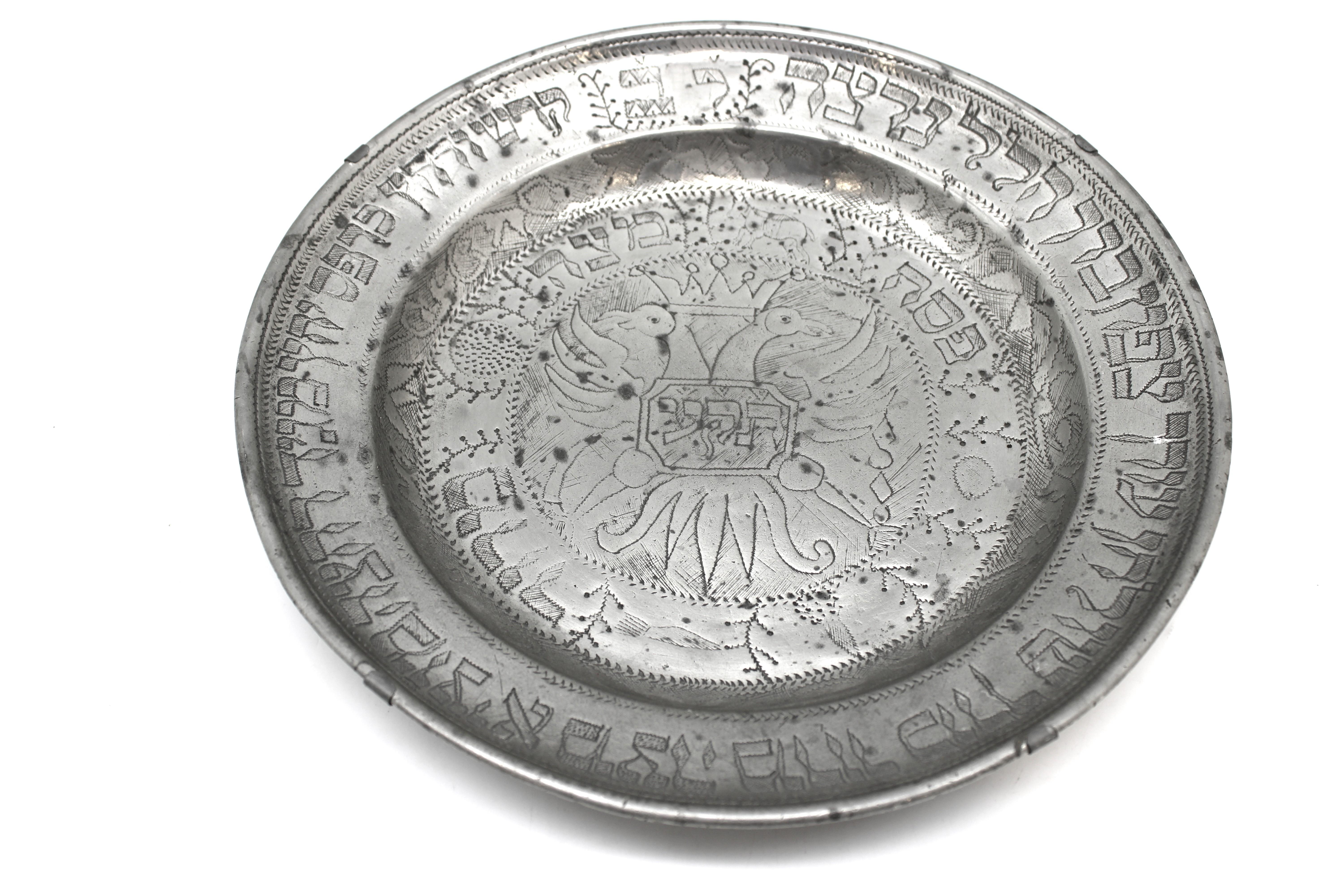 Questo piatto da Pasqua in peltro tedesco, affascinante e storicamente significativo, realizzato nel 1810 circa, è un esempio toccante di Judaica europea creata con mezzi umili ma sentiti. Realizzato interamente in peltro - un'alternativa più