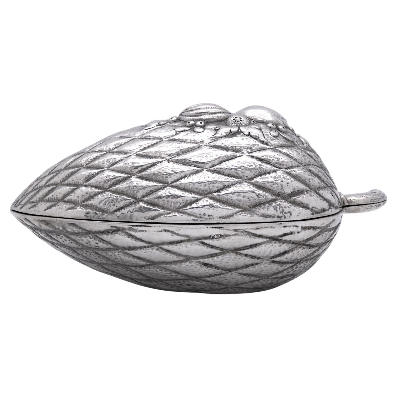 An Exquisite German Silver Etrog Container made in the late 19th century to early 20th Century.

This Etrog Container is shaped in the shape and formed to look like a realistic Etrog.

Hammered diamond-shaped ridges adorn the body of the container