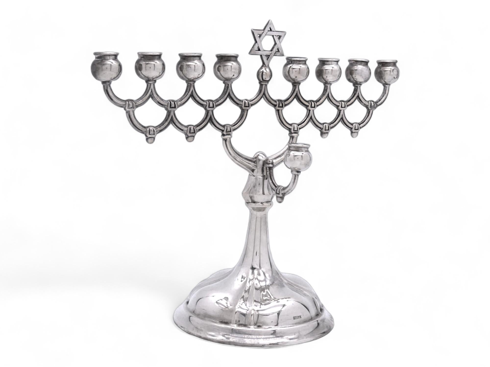 Una atractiva menorá de Hanukkah de Emil Hermann, fabricada en Alemania a principios del siglo XX.

Se trata de una Menorah de plata bastante común para las personas que podían comprar Menorahs de plata en Alemania.

La menorá descansa sobre una