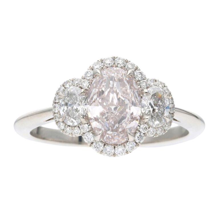 Centering a Light Pink oval diamond, flanked by 2 oval diamonds, accented by a diamond halo.
 - Light Pink diamond weighs 1.01 carat
 - Oval side diamonds weighing a total of approximately 0.30 carat
 - Accent diamonds weighing a total of