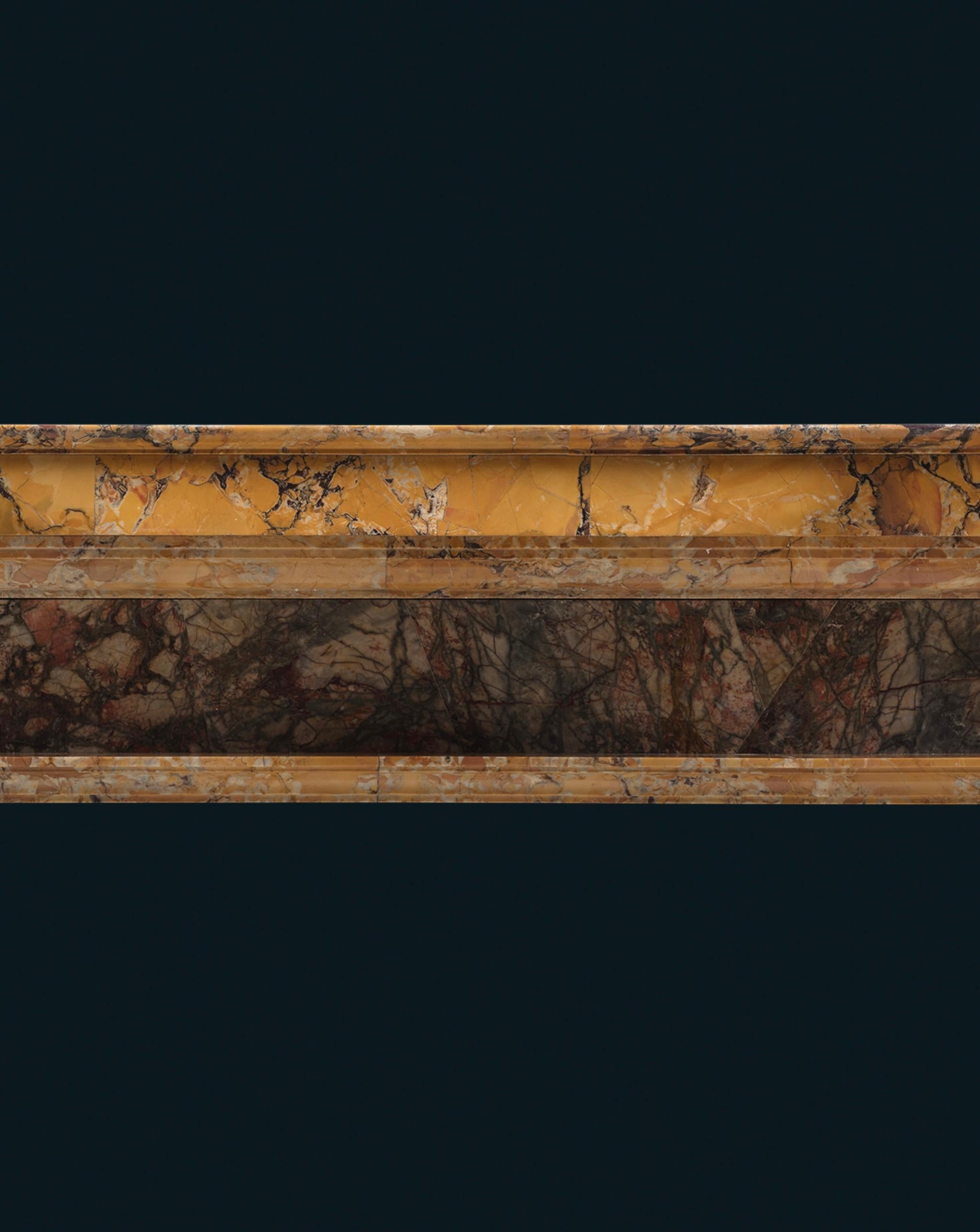Sans doute destinée à l'origine à un intérieur palatial, cette élégante cheminée est sculptée dans trois spécimens différents de marbres colorés très prisés : le Marmo Giallo Siena jaune, favori des Grands Ducs Médicis à Florence ; le Marmo Portoro