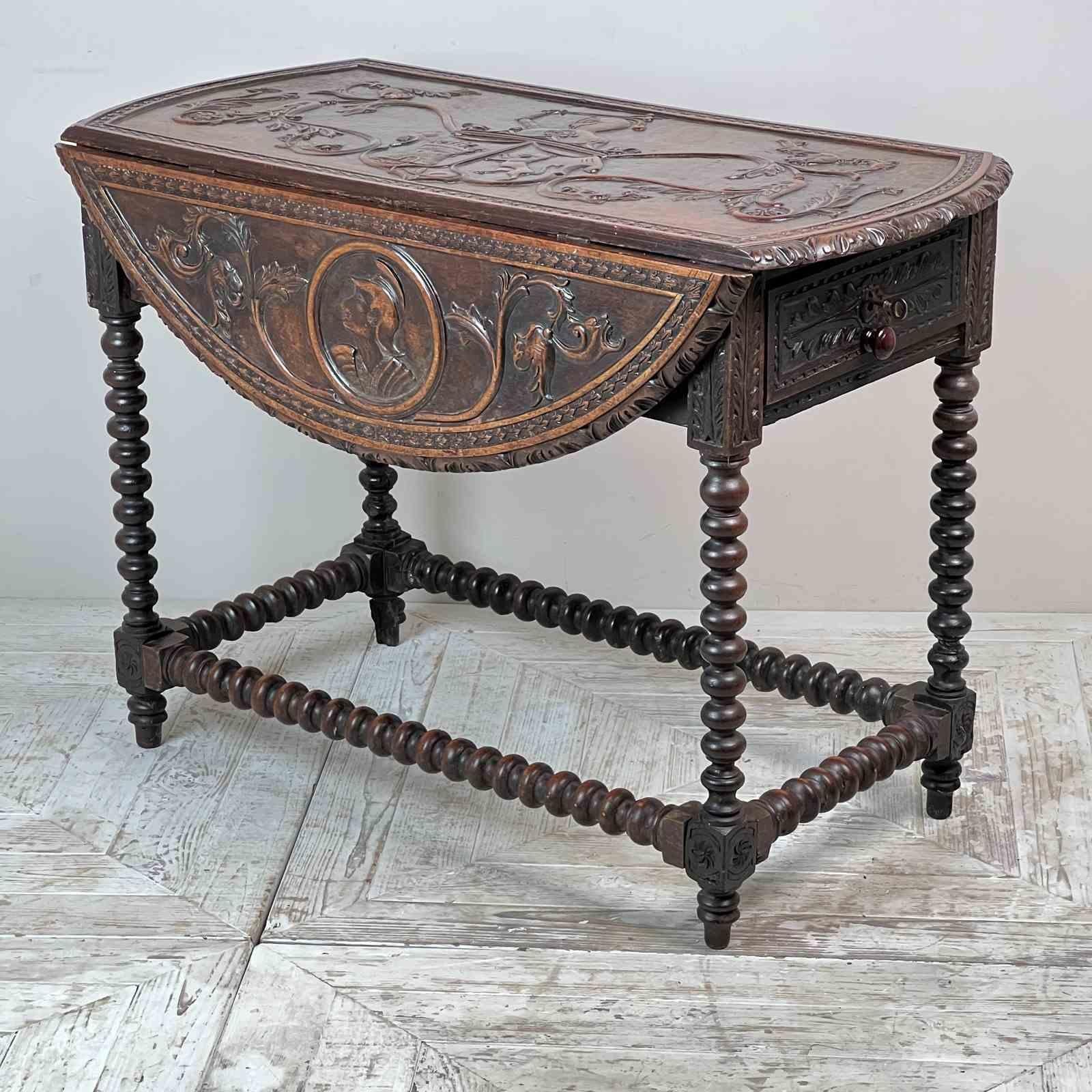 A Gibraltarian Relief Carved Drop Leaf Bobbin Table. The carved top with central coat of arms within a heraldic shield and flanked by pretty scrolling foliage. The triple towered castle is from the Gibraltar coat of arms which was first granted by a