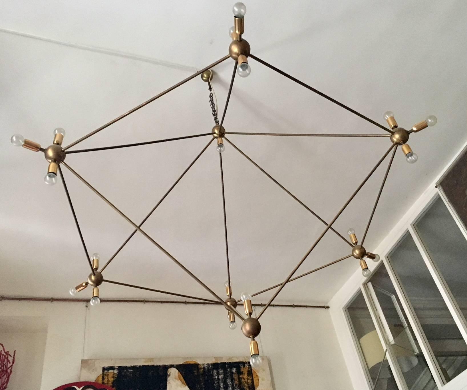 A gigantic chandelier, the asymmetrical pentagonal abstract shaped structure, made of solid brass, with light bronze age patina, create a spectacular illusion of asymmetrical lines and perspectives.
The maximum diameter is 78 in (200 cm) by 63 in