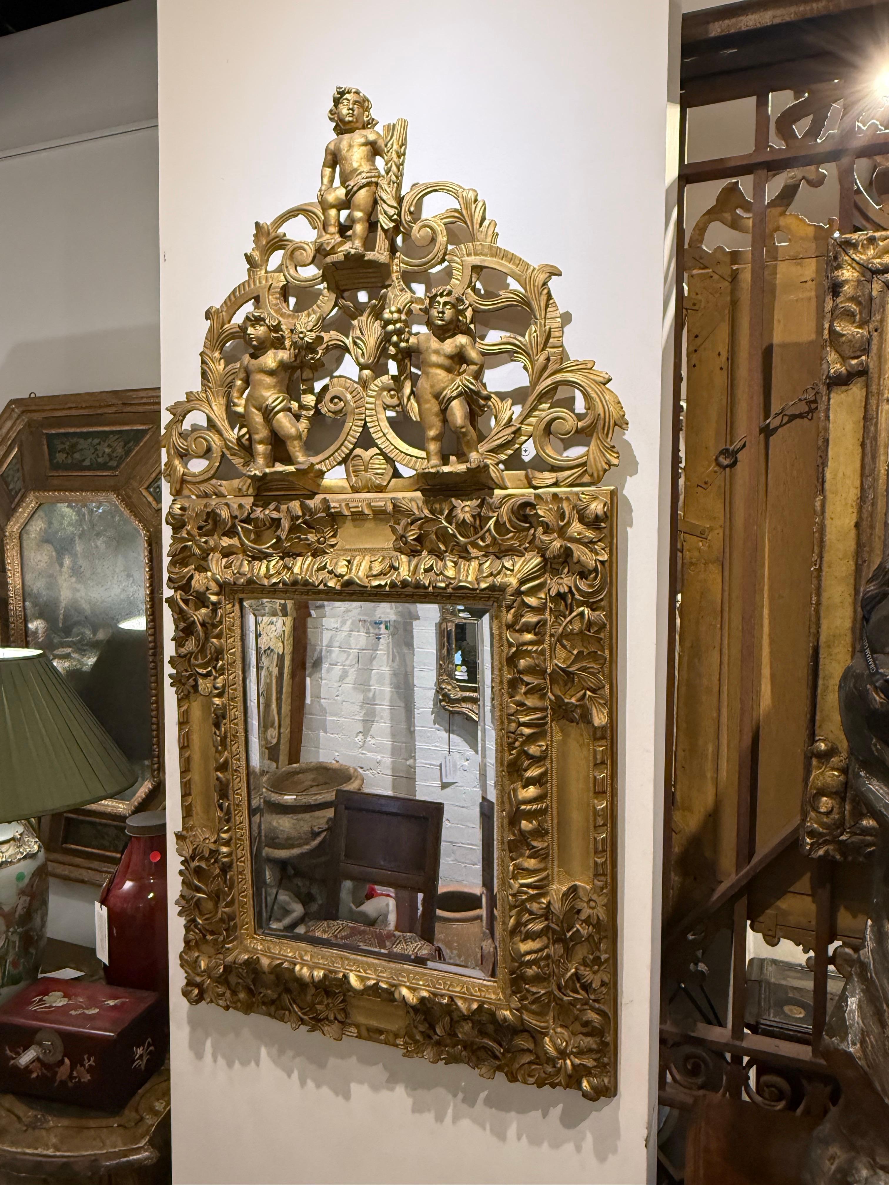 A Gilded Mirror with Three Cherubs, 19th Century

Provenance: Private New South Wales Collection.

Description:
The bevelled glass mirror surmounted by a corona comprising elaborate pierced scrolls, lotus palmette and acanthus leaf motifs,