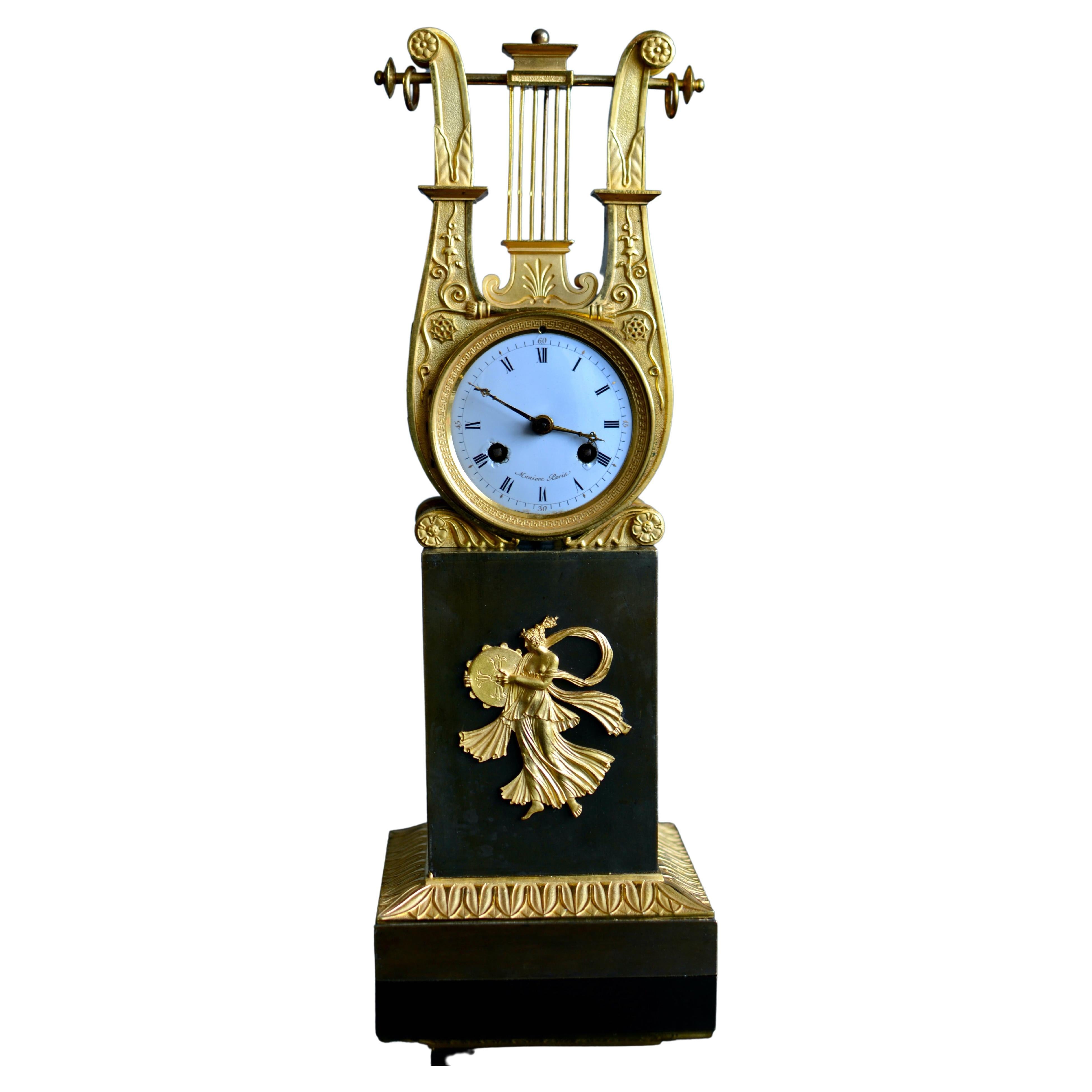 A fine gilt and patinated early empire gilt bronze clock attributed to Thomire. Dial signed Manière Paris. The lyre shaped clockcase is of very high quality with the gilding and the patinated surface in very good condition. The enamel dial is signed