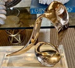 A gilt bronze abstract sculpture by Bill Keating "Surf Rider" on Lucite base