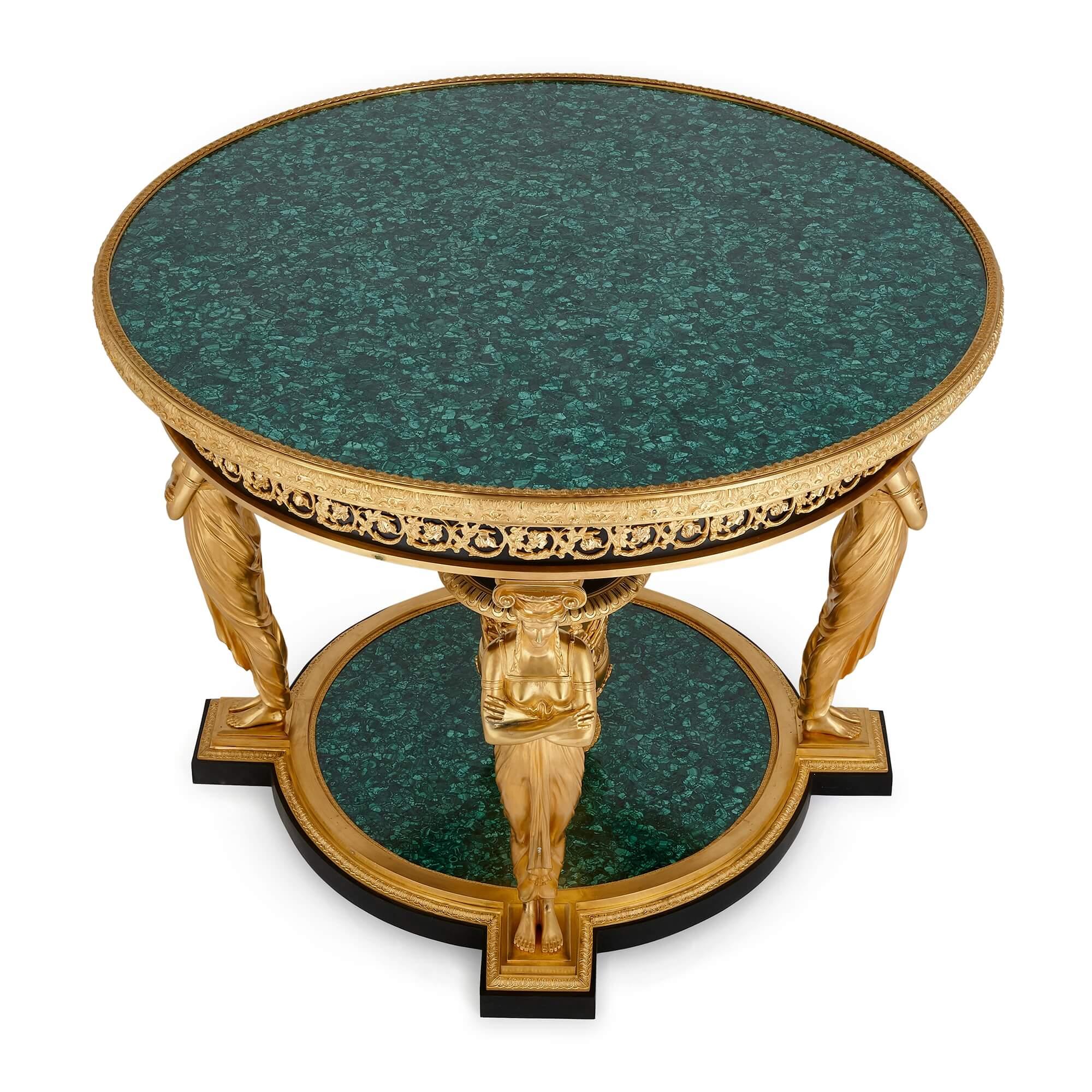 A gilt-bronze and malachite Empire-style 'Aux Caryatides' centre table after Desmalter
French, 20th Century
Height: 82cm, diameter: 109cm

This magnificent piece is an ormolu mounted, malachite and bronze Empire style centre table, after the