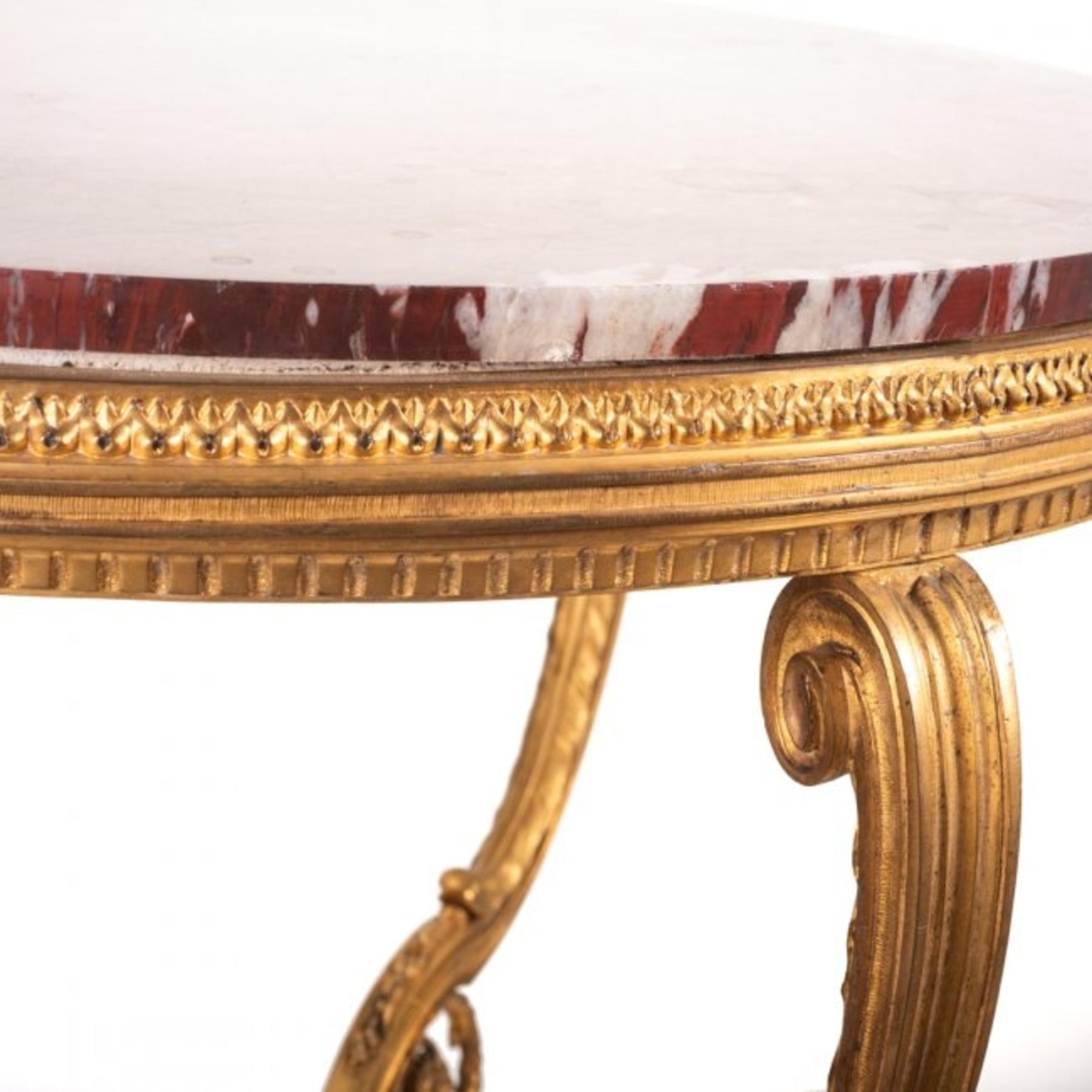 A gilt bronze and red marble guéridon table
in Louis XVI style,
19th-20th century
the top with striated red marble on three shaped legs joined by a circular marble shelf, the clove feet joined by a pierced concave-sided triform