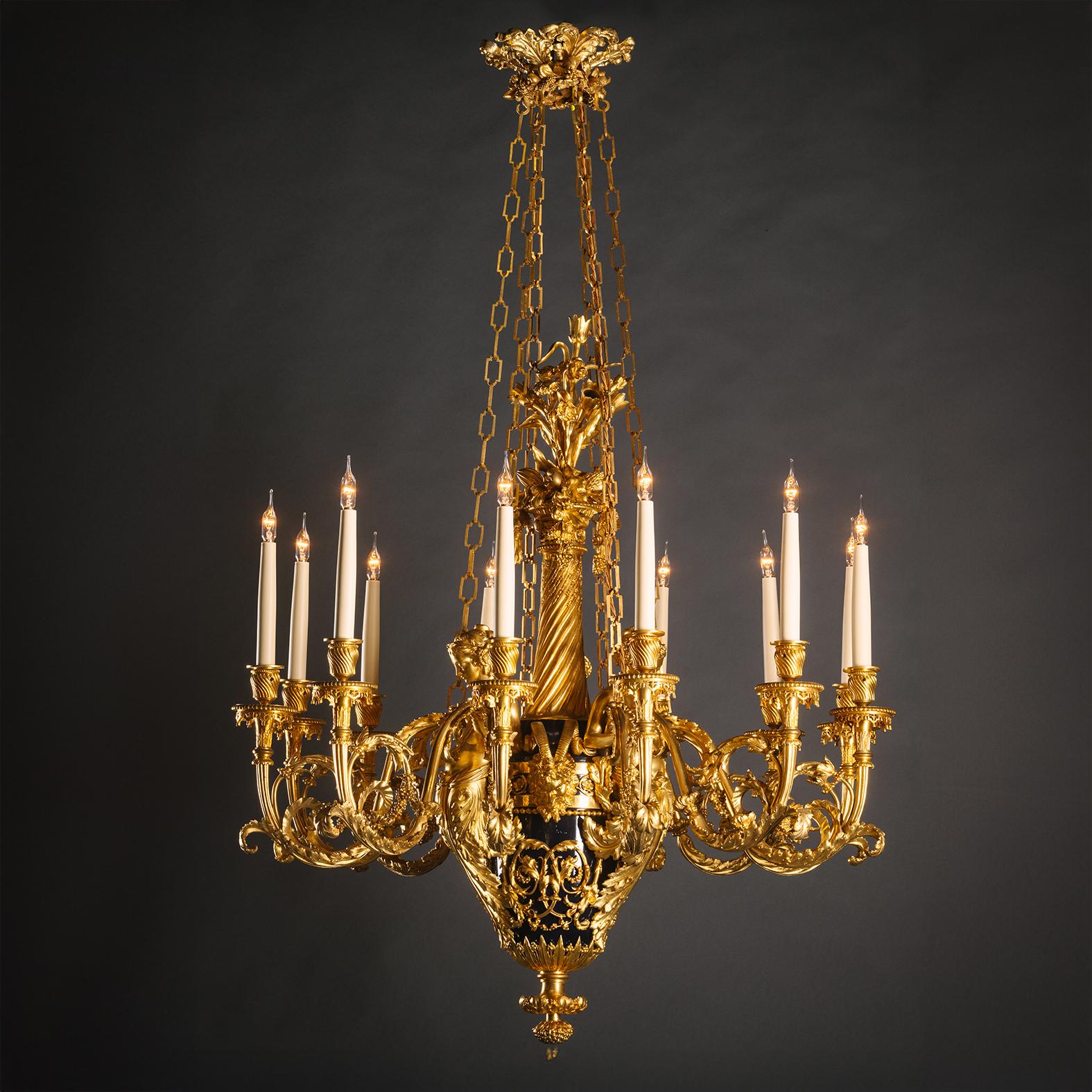 An Important and Monumental Gilt-Bronze and Tole Twelve-Light Chandelier, Attributed to Maison Beurdeley, After The Celebrated Model By François Remond.

The vase shaped body is painted in blue tole and issues a spirally cast finial filled with