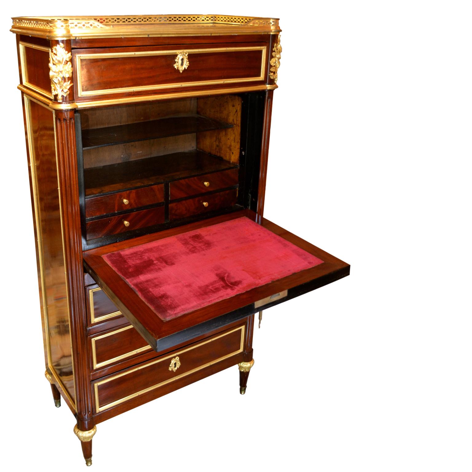 A small scale Louis XVI abbatant (drop front desk) and chest of drawers in mahogany and satinwood with gilded bronze mounts; the satinwood door front opening to reveal a fitted interior and a velvet lined writing surface; the desk surmounted with a