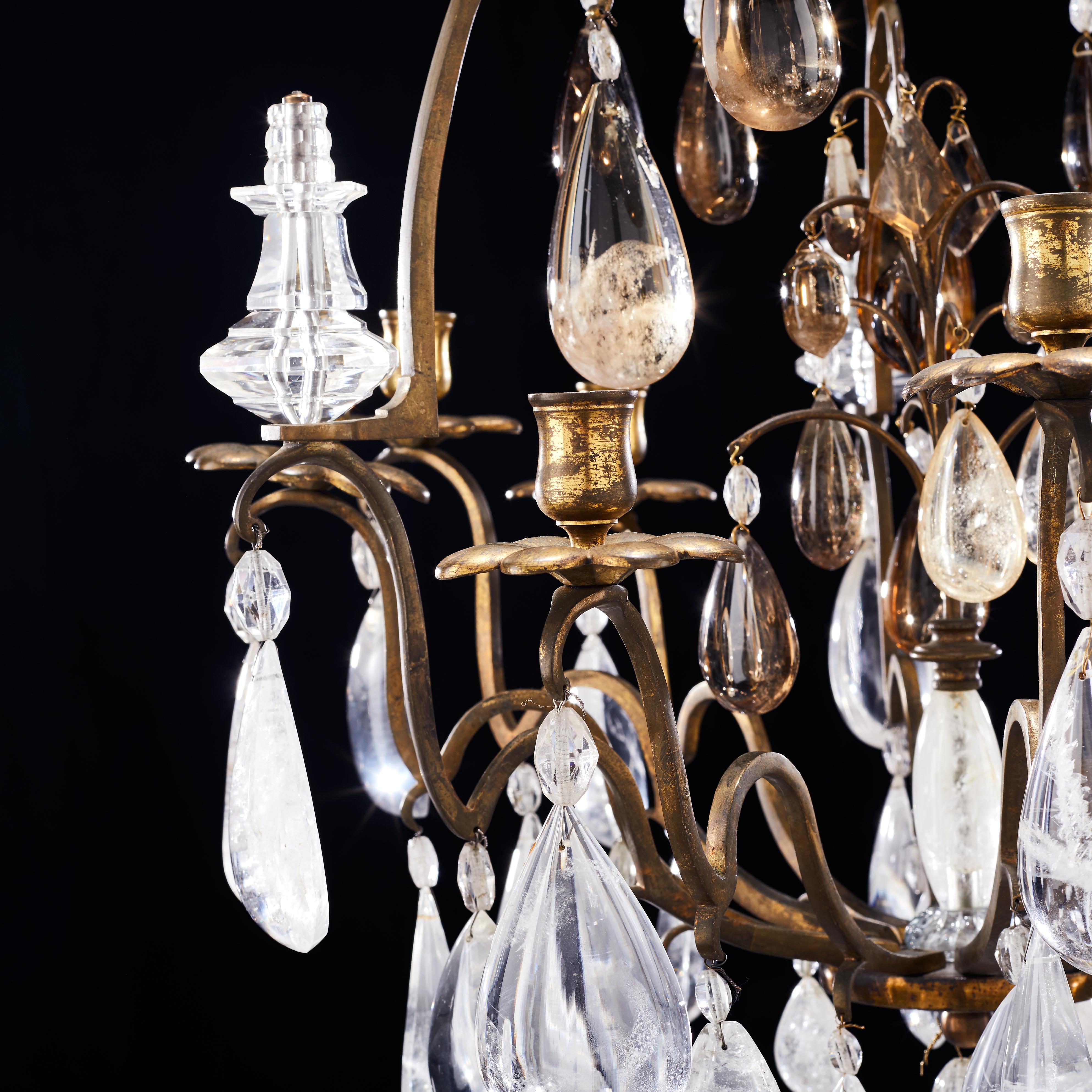 A French gilt bronze rock crystal Louis XV style nine-light chandelier, from the second half of the 19th century. Gilt bronze cage form framework. Some amber-colored rock crystals. 
A very nice and charming chandelier of nice proportions. The