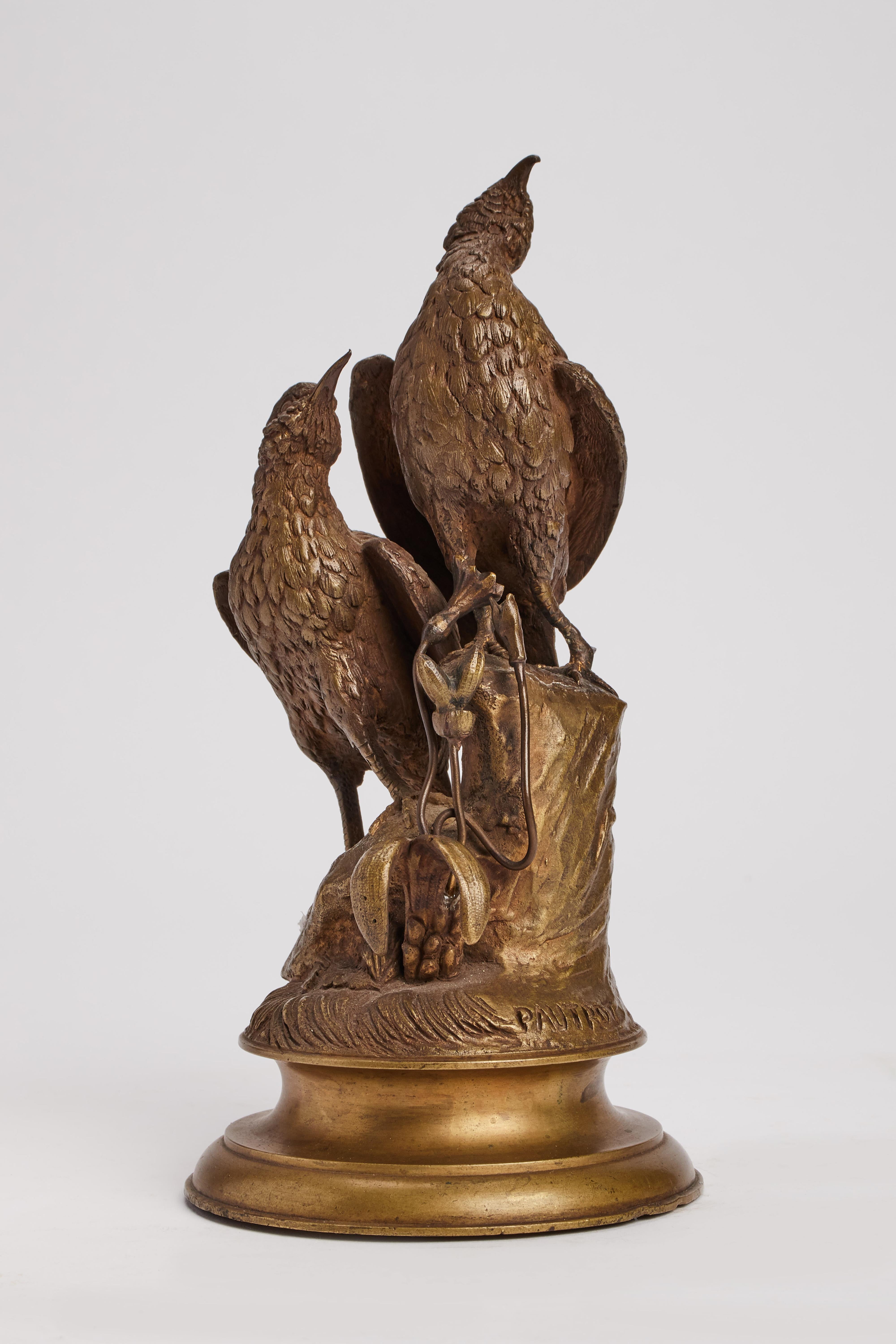 A bronze gilt sculpture of birds are standing over a tree trunk decorated with leaves and flowers. Round plane base. Signed Pautrot, France, circa 1850