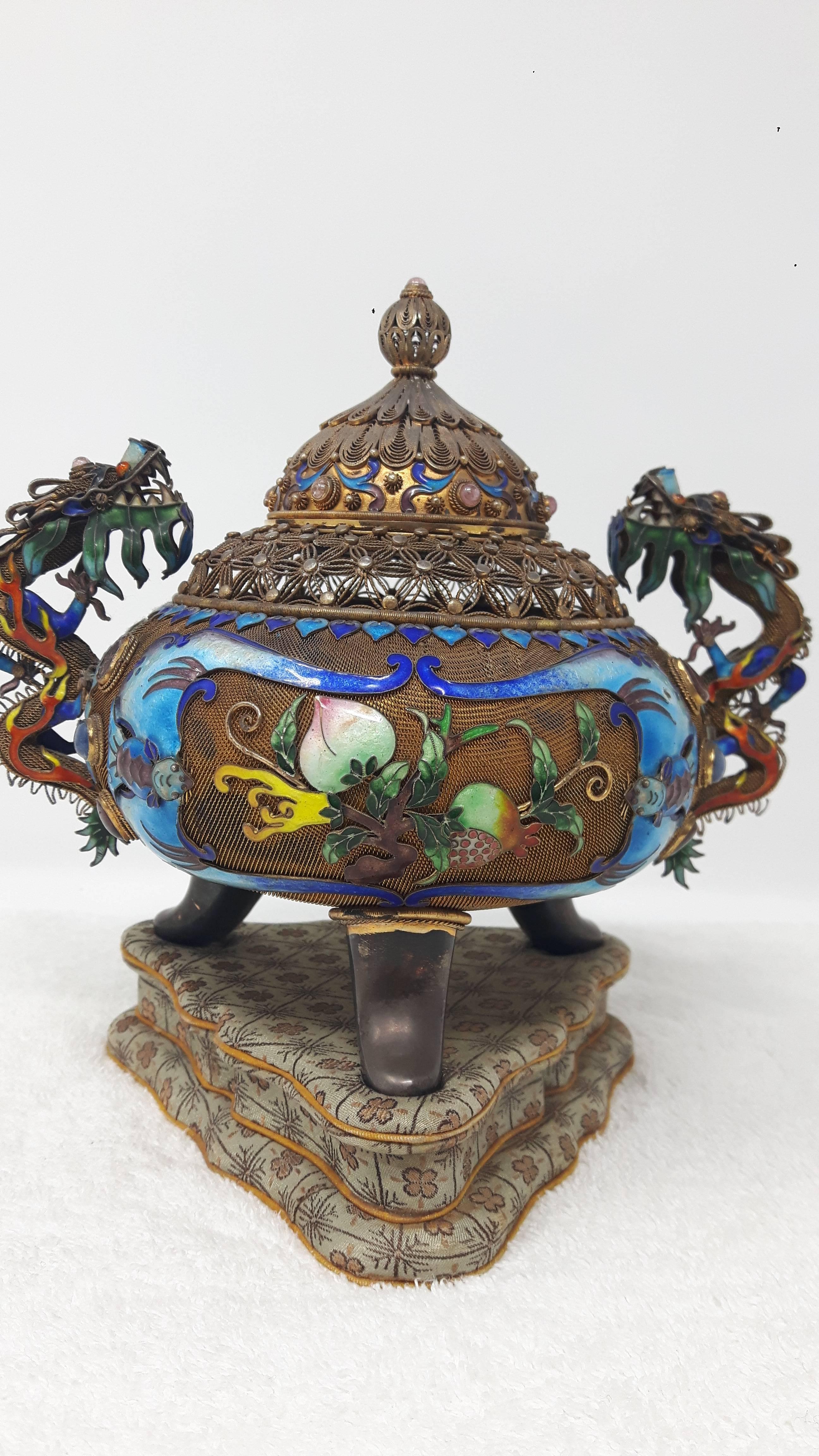 Early 20th century
Of bombé form and raised on tripod feet with applied dragon handles and basket-work filigree neck, the body enamelled with finger citron, peach and pomegranate within an enamelled double-bat framing and with applied cabochon