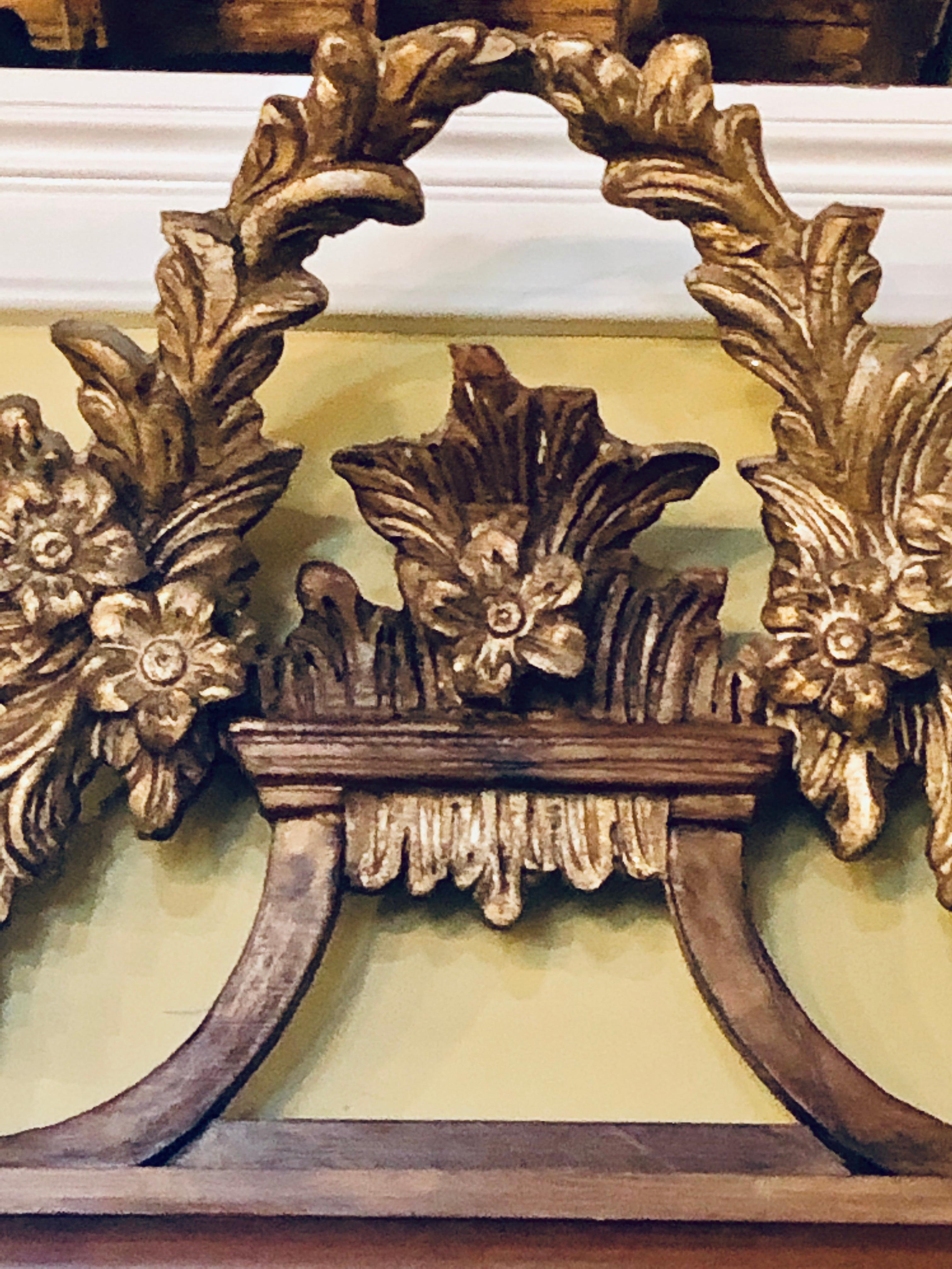 Miroir mural ou miroir de console italien sculpté de feuilles d'acanthe en or doré. Un miroir mural merveilleusement sculpté et détaillé avec un miroir biseauté encadré par un groupe sérieux de sculptures.