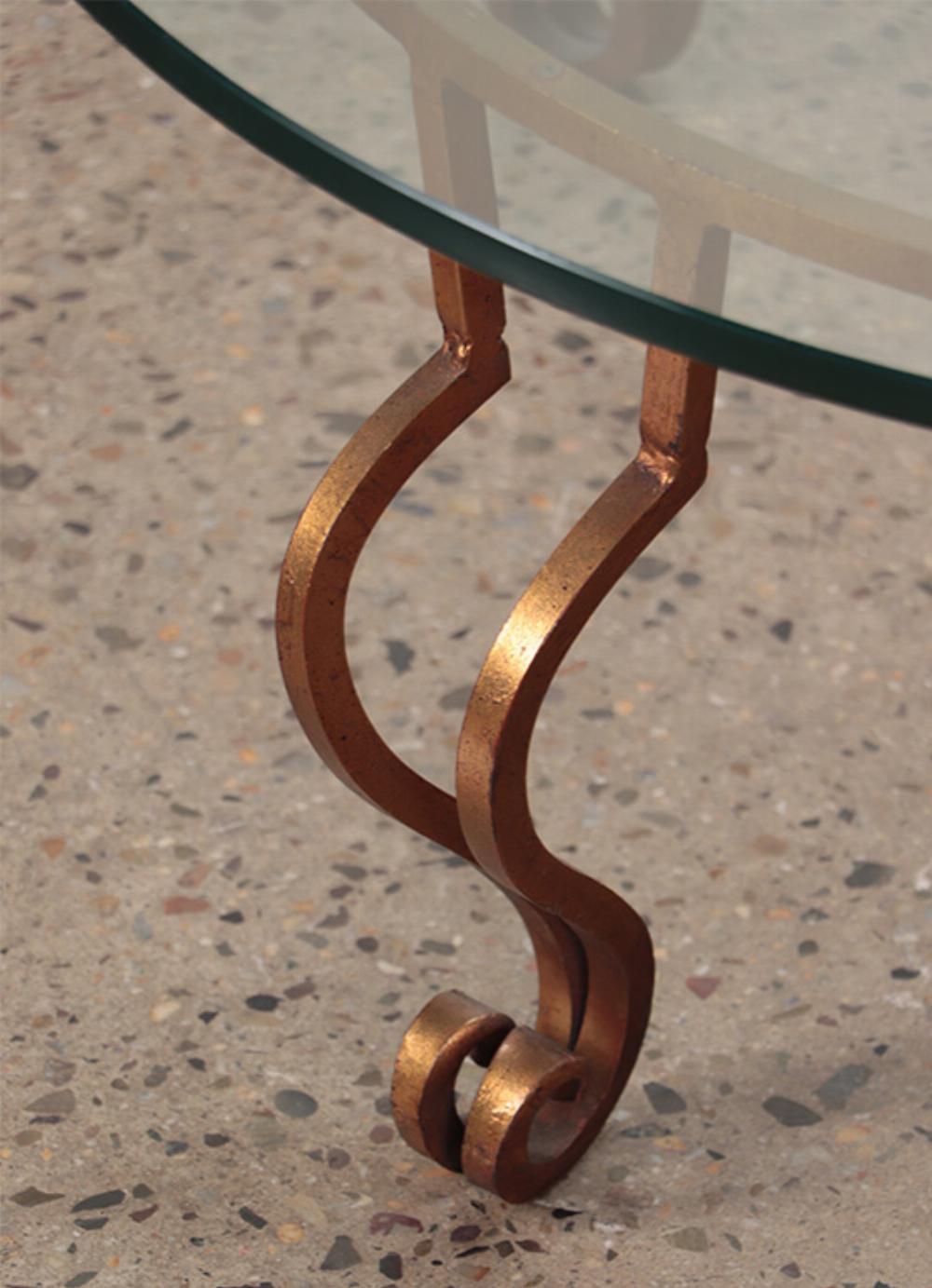 Doré Table basse en fer doré et plateau de verre à la manière de Ramsay, vers 1975. en vente