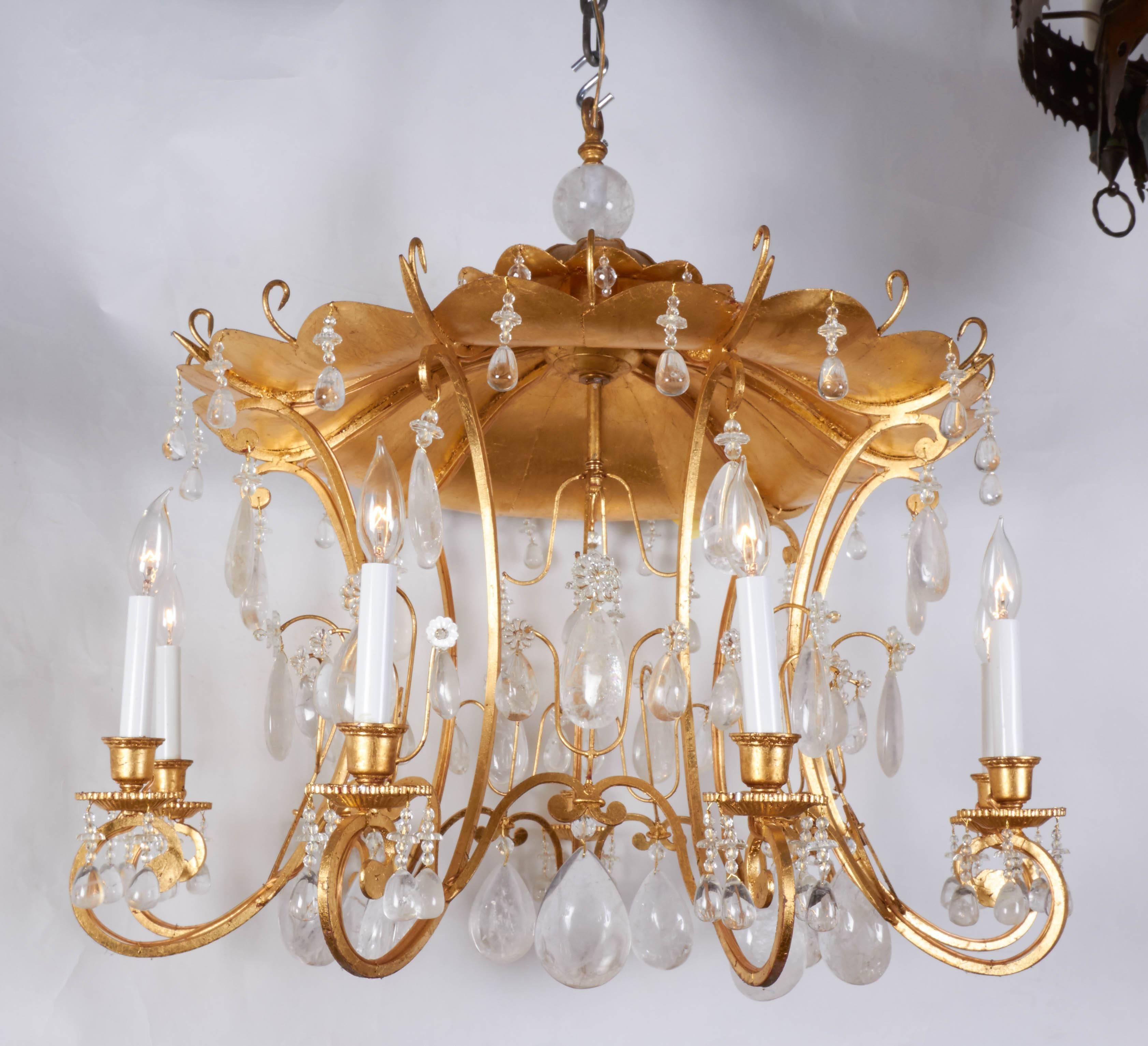 A new chinoiserie style rock crystal and gilt metal eight-light chandelier, the pagoda with eight out-scrolled candle-branches suspending faceted rock crystal drops.