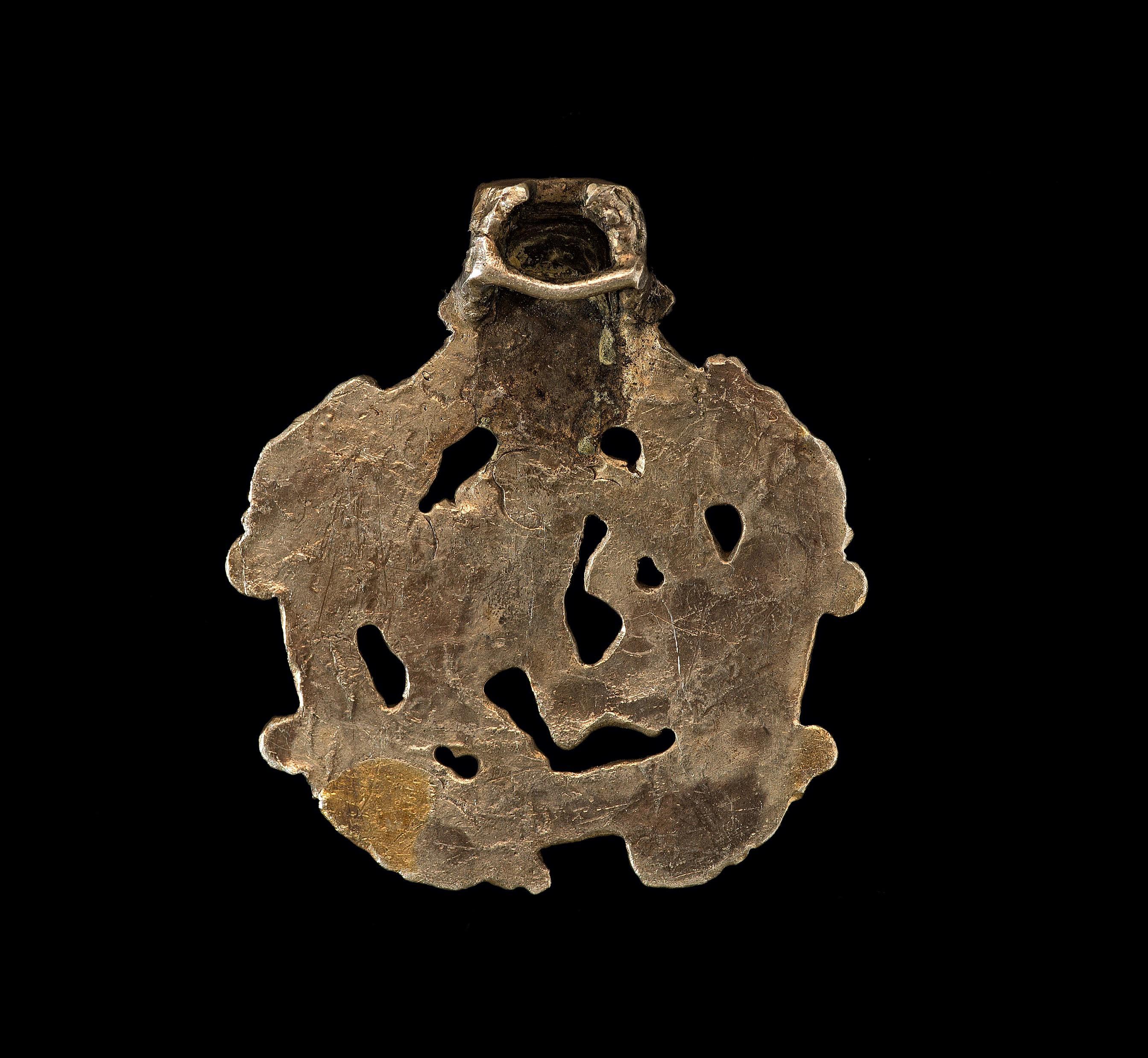 Origin: Viking inhabited area of Europe.

Gilt silver. A Borre-type concave-section pendant with integral suspension loop. The openwork plaque with three-band border and four beast-head panels, internal stylized zoomorphic beast.

Measures: